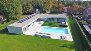 <p><span>Op een prachtig perceel van maar liefst ±30 are, volledig omheind en met optimale privacy, bevindt zich deze uitzonderlijke architecturale laagbouwvilla uit ±2014. Deze moderne L-vormige villa, ontworpen door UAU Architecten, combineert tijdloze elegantie met een ongeëvenaard wooncomfort.</span></p><p><span> </span></p><p><span>De woning onderscheidt zich door haar strakke architectuur en de indrukwekkende glazen achtergevel. Elke leefruimte baadt in natuurlijk licht en geniet van een prachtig zicht op de tuin en het zwembad. Hier ervaart u elke dag opnieuw een vakantiegevoel!</span></p><p><span> </span></p><p><span>Bij binnenkomst verwelkomt de ruime inkomhal met vestiaire en gastentoilet u in een woning waar luxe en functionaliteit perfect samenkomen. De royale leefruimte vormt het hart van de woning. Deze omvat een living met gashaard en tv-hoek, een ruime eetplaats en een hoogwaardige open keuken met centraal kookeiland, dubbele vaatwasser, ingebouwd koffieapparaat en kwalitatieve Miele-toestellen. Aansluitend bevindt zich een uitzonderlijk grote bijkeuken die extra comfort biedt.</span></p><p><span> </span></p><p><span>Een op maat gemaakte kastenwand met geïntegreerd bureau vormt de verbinding tussen de leefruimte en een polyvalente ruimte. Deze is momenteel ingericht als fitnessruimte, maar kan eveneens perfect dienstdoen als gastenverblijf. De ruimte beschikt over een eigen douche, toilet en wastafel. Ook de nodige voorzieningen voor de installatie van een sauna zijn aanwezig. </span></p><p><span> </span></p><p><span>Het nachtgedeelte bevindt zich in de andere vleugel van de woning en garandeert optimale rust. Hier bevinden zich een bureau- of hobbyruimte en twee ruime kinderkamers, elk voorzien van een eigen douchekamer, toilet, bureau en ingebouwde kasten. De luxueuze mastersuite beschikt bovendien over een ruime inloopdressing en een privébadkamer met inloopdouche en vrijstaand ligbad. </span></p><p><span> </span></p><p><span>De villa onderscheidt zich door haar bijzonder praktische indeling, waarbij elke vierkante meter optimaal wordt benut. Dankzij de volledig ingebouwde afwerking en maatwerkkasten geniet u van maximaal comfort en veel bergruimte.<br /><br />Het zwembad van 15 meter op 5 meter wordt omringd door een ruim zonneterras. Het overdekte terras (5 op 5 m) biedt de ideale setting om het hele jaar door te genieten van het buitenleven, steeds met volledige privacy en een perfecte westoriëntatie.</span></p><p><span> </span></p><p><span>Ook op technisch vlak voldoet deze villa aan de hedendaagse normen. De woning is voorzien van onder meer over 22 zonnepanelen, een laadpaal voor elektrische voertuigen, vloerverwarming, een ventilatiesysteem en een warmtepomp voor zowel airconditioning als zwembadverwarming.</span></p><p><span> </span></p><p><span>Verder beschikt de villa over een dubbele inpan</span><span>dige garage met inbouwkasten. </span></p><p><span> </span></p><p><span>Een unieke eigendom voor wie op zoek is naar architectuur, luxe, ruimte en absolute rust nabij stad! </span></p><p><span> </span></p>