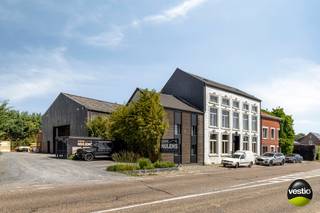 Karaktervol gerenoveerd vastgoedcomplex bestaande uit een stijlvolle woning met bureelruimte, een achterliggend magazijn, gunstig gelegen aan de Maastrichtersteenweg 244-246 te Tongeren.<br /><br />Dankzij de uitstekende ligging langs de gewestweg N79 tussen Riemst en Tongeren, en op korte afstand van de autosnelweg, geniet deze eigendom van een vlotte bereikbaarheid.<br />Winkels en dagelijkse voorzieningen bevinden zich op enkele autominuten.<br />Het geheel is gelegen op een perceel van 14a 20ca en biedt tal van mogelijkheden, waaronder privébewoning gecombineerd met kantoor- of praktijkruimte.<br />Zowel vooraan als op het terrein zelf is ruime parkeergelegenheid voorzien.<br /><br /><u><strong>Woning met bureelruimte:</strong></u><br />De authentieke woning (186 m²), gecombineerd met een bureelgedeelte van ca. 70 m², werd met oog voor detail gerenoveerd waarbij het oorspronkelijke karakter zorgvuldig bewaard bleef. De ruime indeling, overvloedige lichtinval en stijlvolle afwerking zorgen voor een bijzonder aangename woon- en werkomgeving.<br /><br />Via de centrale inkomhal bereikt men enerzijds het private woongedeelte en anderzijds de bureelruimte.<br />Het woongedeelte omvat een royale en lichtrijke leefruimte, aansluitend op een volledig ingerichte landelijke keuken met ruime eethoek en een prachtig zicht op de binnentuin, bereikbaar via een schuifpui. Verder beschikt de woning over een praktische berging.<br /><br />Op de eerste verdieping geeft de overloop toegang tot de master bedroom met geïntegreerde dressing en een ensuite badkamer uitgerust met een vrijstaand ligbad, wastafel, ruime inloopdouche en afzonderlijk toilet.<br />De tweede slaapkamer beschikt over een naastgelegen bureelruimte en biedt doorgang naar de wasruimte.<br /><br />De tweede verdieping (82m²) werd reeds voorbereid voor verdere afwerking tot twee bijkomende slaapkamers met dressing en badkamer.<br />De vloer is voorzien van OSB-platen en de wanden en plafonds werden afgewerkt met gipsplaten.<br /><br />Daarnaast is de woning grotendeels onderkelderd (ca 85m²) en beschikt zij over diverse praktische bergruimtes.<br /><br />De kantoorruimte omvat een indrukwekkende nokhoge bureelruimte, een extra kantoor, kitchenette en gastentoilet. Via de sfeervolle binnentuin staat deze ruimte bovendien in directe verbinding met het achtergelegen magazijn.<br />Voorzien van alarm en camerabewaking. <br /><br /><u><strong>Magazijn:</strong></u><br />Het magazijn (382 m²) is bereikbaar via een automatische toegangspoort en omvat een ruime opslagplaats, afzonderlijke bureelruimte. Op de verdieping is er bijkomende opslagruimte en een bergruimte.<br />Achteraan bevindt zich overdekte opslagruimte (21m²). Het gebouw is uitgerust met twee sectionaalpoorten.<br /><br /><br /><u>Belangrijkste troeven van deze aanbieding zijn:</u><br /><br />- Uitstekende ligging langs de N79 tussen Riemst en Tongeren, nabij de autosnelweg.<br />- De voorgelegen weg wordt binnenkort volledig heringericht met extra groenvoorzieningen, wat de omgeving en uitstraling aanzienlijk zal versterken.<br />- Uniek vastgoedcomplex bestaande uit woning, burelen en magazijn.<br />- Veelzijdig inzetbaar voor privébewoning, kantoor, praktijkruimte of combinatie van wonen en werken.<br />- Ruime parkeermogelijkheden op eigen terrein.<br /><br /><br />Voor meer info of een bezoek ter plaatse, contacteer ons op 0473 79 29 30 of mail naar luc@vestio.com <br /><br /><br /><br /><br /><br /><br /> 