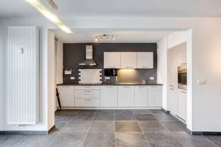 Bent u op zoek naar 2 slaapkamer appartement met extra polyvalente ruimte? Dan is dit precies wat u zoekt!<br />Dit appartement bevindt zich op de vijfde verdieping (met lift) op een centrale locatie! <br /><br />Indeling:<br />U komt binnen in de centraal gelegen inkomhal met vestiaire. Onmiddellijk rechts vindt u het apart toilet met handenwasser en de aansluiting voor wasmachine en droogkast. Tegenover de inkom is er een polyvalente ruimte die kan dienen als een bureau of dressing. <br />Vanuit de inkomhal kan u links doorlopen naar de twee slaapkamers en de badkamer met enkel lavabomeubel, ligbad, toilet en handdoekradiator. <br /><br />Tot slot bereikt u vanuit de inkomhal de grote leefruimte met veel lichtinval en aansluitend een open keuken. De leefruimte geeft via het schuifraam toegang tot het terras vooraan. De open keuken is volledig uitgerust met een microgolfoven, vaatwasmachine, oven, kookplaat en dampkap, enkele spoelbak, ingebouwde koelkast en diepvries. Ook via de keuken kan u het terras bereiken via het grote raam met een extra vliegenraam. <br /><br />Verder is er nog een privatieve kelderberging en een gemeenschappelijke fietsenstalling.<br /><br />De maandelijkse kosten bedragen €250/maand. Deze omvatten: provisie water, verwarming, onderhoud lift, minuterie en onderhoud gemene delen.<br /><br />Pluspunten:<br />-Ideale ligging: nabij openbaar vervoer, invalswegen, groen, …<br />-Privatieve kelderberging<br />-Gemeenschappelijke fietsenstalling<br />-Beschikbaarheid vanaf 01/11/2026