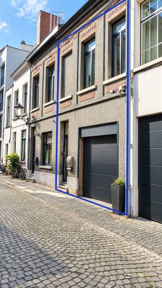 <p><span>Op amper 50 stappen van de gezellig drukke Grote Markt, ligt deze in 2024 gerenoveerde woning. In het stadscentrum is een grote garage met afstandsbediende poort goud waard. U kan er met een bestelwagen of 2 auto’s binnen. De Standonckstraat is voorzien van kasseiverharding en is voor auto’s doodlopend. De rustig gelegen woning met authentieke gevel, wordt opgefleurd door een plint in blauwe hardsteen en donkergrijze ramen (2017). Binnen worden we gecharmeerd door de hoge plafonds en de authentieke accenten: originele vloertegels, authentieke geschilderde trap, accentmuur in zichtbaar metselwerk. Open keuken (2024) en living krijgen in één hoek nog veel extra licht binnen via ramen rond de buitenruimte. De keuken omvat een oven, kookplaat, dampkap, koelkast, aparte freezer en een vaatwasser. Op de eerste verdieping, naast het toilet, staat een berging/wasplaats ter beschikking, terwijl ook op de 2</span><span><sup>e</sup></span><span> verdieping nog extra bergruimte beschikbaar is. De koelte wordt zowel op de eerste als op de tweede verdieping gegarandeerd door de aircotoestellen met warmtepomptechnologie. Onder dak werden de twee slaapvertrekken gescheiden door een wand in loftstijl, aangevuld door een open badkamerruimte: douchecabine in glas met regendouche en lavabomeubel met spiegel. </span></p><p><span> </span></p>