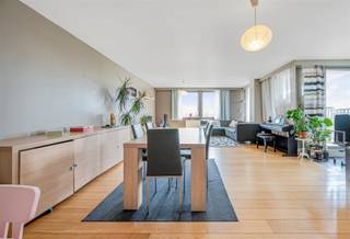 Op zoek naar een ruim en lichtrijk appartement in het centrum? Dan is dit appartement van maar liefst 126 m² op de vierde verdieping van residentie Boudelo zeker een bezoek waard. Dankzij de hoekligging — op de kruising van de Plezantstraat en de Hofstraat — geniet je hier van een wijds, open uitzicht over Sint-Niklaas.De lift brengt je comfortabel tot aan de voordeur. Binnenin vind je een ruime inkomhal, een gezellige leefruimte met parketvloer en eetplaats, en een open keuken die mee in verbinding staat met de woonkamer — ideaal voor wie houdt van openheid en gezelligheid. Verder zijn er twee volwaardige slaapkamers, een ingerichte badkamer en een aangenaam terras waar je volop kan genieten van zon en stadse rust.Als extra pluspunt beschikt dit appartement over een private autostaanplaats en twee extra bergingen (nr. 28) in de ondergrondse parkeergarage (-2).EPC = A label
