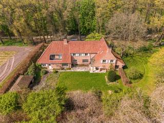 INDIEN U EEN BEZOEK WENST IN TE PLANNEN GELIEVE EEN AANVRAAG TE MAILEN NAAR TINNE.VAN.MECHELEN@HILLEWAERE.BE<br /><br />BEKIJK ALLE FOTO'S OP WWW.HILLEWAERE.BE<br /><br />Een charmante villa gelegen op maar liefst 2,9 hectare, verborgen in alle rust, midden in het groen in Oud-Turnhout. Deze landelijke villa uit 1981 biedt een indrukwekkende bewoonbare oppervlakte van ca. 500 m², met vier slaapkamers en twee badkamers. Dit alles op een prachtig domein waar privacy en natuur centraal staan.<br /><br />Indeling:<br />Bij het binnenkomen word je verwelkomd in een statige inkomhal met vestiaire en gastentoilet. Van hieruit ga je naar het hart van de woning: een gezellige woonkamer met open haard en een aparte zithoek waar knusse avonden vanzelfsprekend worden. Een trap leidt vanuit de zithoek naar een ondergrondse wijnkelder.<br /><br />Aansluitend bevindt zich een sfeervolle bibliotheek- of bureauruimte met een grote charmante raampartij. Via een dubbele deur betreed je de eetkamer, afgewerkt met een parketvloer en zicht op de tuin, ideaal voor lange diners in goed gezelschap.<br /><br />De ruime leefkeuken heeft een authentieke sfeer en is heel functioneel, uitgerust met alle nodige toestellen en een mooi marmeren werkblad. De aangrenzende ontbijthoek maakt dit tot een heerlijke plek om de dag te starten. Vanuit de keuken bereik je de praktische wasplaats, die op haar beurt toegang geeft tot een douche, een apart toilet en de inpandige garage met automatische poort.<br /><br />Eerste verdieping:<br />Op de eerste verdieping vinden we de mastersuite met een eigen salon met open haard en een aansluitende badkamer. Daarnaast zijn er nog drie volwaardige slaapkamers en een tweede badkamer. De polyvalente ruimte biedt een open zicht op de bibliotheek beneden en versterkt het gevoel van ruimte en licht in de woning.<br /><br />Tuin:<br />De tuin is een prachtig verlengstuk van de woning. Idyllisch, waar u volledig tot rust komt. Na een lange werkdag biedt het groen alle ruimte om te ontspannen, met de handen in de aarde of genietend van de stilte op het terras onder de prachtige druivelaar of in het overdekte houten bijgebouw. Via een charmant poortje kom je tot een indrukwekkend stuk parktuin. Schitterende vijver, mooie appelboomgaard en bos.<br /><br />Kortom, een uitzonderlijke plek!<br /><br />Bijzonderheden:<br />- Onmiddellijk beschikbaar<br />- Verwarming op stookolie<br />- Vloerverwarming<br />- Prachtige parktuin<br />- Unieke locatie