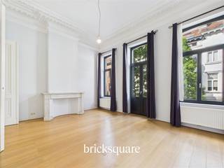 Located just a stone's throw from the European institutions, between Place Flagey, Place Jourdan and Place Saint-Boniface, this bright, functional apartment is on the 1st floor and entresol of a 19th-century maison de Maître, completely renovated in 2010. It combines old-world charm with today's standards of comfort.With a floor area of 103 m² and a ceiling height of 4 meters, this property offers spacious accommodation. At the front, a spacious living room opens onto a small balcony. A central room, adorned with period moldings and marble fireplaces, provides a versatile and welcoming space. The semi-open, fully-equipped kitchen features a large bay window, bringing light and calm. A discreet laundry room completes the ensemble.The night space is accessed by an oak staircase and includes a full bathroom (bath, walk-in shower, washbasin, WC) as well as a bedroom or study at the rear and an integrated dressing room.The property is part of a small co-ownership of three lots, with low charges. It benefits from compliant electricity, EPC C- certification and quality renovation.Available immediately. An opportunity for those looking for a property with character, in a quiet, central and sought-after area.📞 For more information, contact BrickSquare on 02/315.25.13🌐 www.bricksquare.be