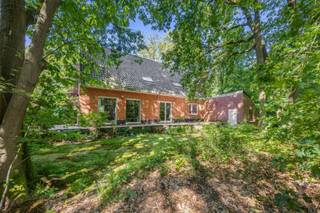 Gelegen op een idyllisch perceel van maar liefst 2.224 m², verscholen in het weelderige en rustgevende groen, presenteren wij deze royale vrijstaande villa. Met een bewoonbare oppervlakte van circa 230 m² en een bosrijke tuin biedt dit eigendom een zeldzame basis voor wie op zoek is naar ultieme rust, privacy en de unieke kans om een droomwoning volledig naar eigen hand te zetten. De statige architectuur met de warme rode baksteen en de omringende volwassen bomen zorgen bij aankomst direct voor een warm en exclusief gevoel.
De binnenzijde van de villa kenmerkt zich door een uiterst doordachte indeling met een zee aan ruimte. Op het gelijkvloers bevindt zich, naast de keuken en leefruimte met prachtig zicht op de omliggende natuur, een praktische kantoorruimte. Deze kamer leent zich uitstekend als thuiswerkplek of als volwaardige extra slaapkamer op de begane grond. Op de bovenverdieping biedt de woning ruimte aan vier comfortabele, volwaardige slaapkamers, waardoor het pand perfect beantwoordt aan de noden van een groot gezin.
Een absolute en unieke troef van dit vastgoed is de riante aanpalende werkplaats. Deze multifunctionele ruimte biedt tal van architectonische en professionele perspectieven. Dankzij de royale oppervlakte en de directe verbinding met het hoofdgebouw transformsert u deze zone moeiteloos tot een high-end praktijk voor een vrij beroep, een inspirerend kunstenaarsatelier, of een stijlvol thuiskantoor met eventueel een aparte toegang voor cliënten.
De woning beschikt momenteel over een EPC-score F, wat een renovatieverplichting met zich meebrengt. Dit is echter de uitgelezen kans voor de meerwaardezoeker. De solide constructie en de royale volumes nodigen uit om deze villa te moderniseren naar de allerhoogste hedendaagse normen van luxe, comfort en energie-efficiëntie. Met de juiste visie transformeert u dit object in een ecologisch en esthetisch meesterwerk. Laat u betoveren door de ongekende potentie en de magnifieke groene setting van deze villa en maak van dit project uw eigen exclusieve parel.