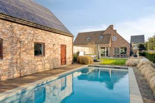 Deze ruime woning is gelegen op een prachtig perceel van 1.474 m² met een praktisch bijgebouw van maar liefst 75 m², een ingebouwd zwembad en een poolhouse. De woning profiteert van een gunstige ligging met Balen - Centrum op slechts 1,5 km en een groene omgeving met o.a. de Keiheuvel. <br /><br />De woning werd gebouwd in 2000 met aandacht voor een praktische indeling, aangenaam veel lichtinval en ruimte. We betreden de woning via de ruime inkomhal met toegang naar de bureauruimte en de leefruimte. De bureauruimte kan ideaal ingericht worden als ontvangstruimte, werkplaats of extra kamer. De ruime leefruimte (45m²) is opgesplitst in een eethoek en zithoek en is voorzien van bekabeling voor een surround systeem. Aansluitend bevindt zich de keuken voorzien van een koelkast, inductiekookplaat, afzuigkap, vaatwasser, stoomoven, lavabo en koffiemachine. Hier bevindt zich tevens ruimte voor een eettafel met een prachtig zicht naar de tuin. Ook de badkamer bevindt zich op het gelijkvloers en is uitgerust met een inloopdouche en dubbele wastafel in meubel. <br />Het is dus mogelijk om volledig gelijkvloers te leven! <br /><br />Achteraan de woning bevindt zich de achterinkomhal met doorgang naar de tuin, het gastentoilet en de ruime (verwarmde) garage. <br /><br />De vier slaapkamers en extra berging bereikbaar op de eerste verdieping zijn bereikbaar via de charmante vaste trap. <br /><br />In de tuin geniet je tijdens de zomermaanden optimaal dankzij het ingebouwd zwembad met bijhorende poolhouse. Dit poolhouse is de ideale plaats om te genieten van de zon dankzij o.a. het zongeoriënteerde terras. Binnenin is deze afgewerkt met een verwarmde zithoek, badkamertje (douche en toilet) en keukentje. <br /><br />Het praktische bijgebouw van 75 m² is momenteel ingericht als garage maar kan ook prima anders benut worden. Hier zijn tal van mogelijkheden.<br /><br />* EPC A-label ! <br />* vloerverwarming<br />* 33 zonnepalen (10.890 Wp)<br />* inpandige garage + grote garage/ bijgebouw met alle voorzieningen <br />* verwarmd zwembad<br />* alarmsysteem<br />* zeer veel parkeermogelijkheden