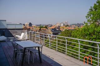 <strong>Une résidence d'exception à la Résidence Tennis Garden</strong><br />Découvrez ce <strong>spacieux penthouse de 128 m²</strong>, situé au <strong>5</strong><strong>ᵉ</strong><strong> étage de la Résidence Tennis Garden à Ostende</strong>.<br />Ce bien unique allie de généreux espaces de vie, d'immenses terrasses et une vue panoramique exceptionnelle.<br />Grâce à son emplacement privilégié, à ses finitions soignées et à son excellent état d'entretien, ce penthouse convient parfaitement comme <strong>résidence principale</strong>, <strong>résidence secondaire</strong> ou <strong>investissement immobilier sur la Côte belge</strong>.<br /><br /><strong>Un espace de vie lumineux et spacieux</strong><br />L'entrée s'ouvre sur un hall avec toilettes invités. Le <strong>séjour lumineux</strong> bénéficie de grandes baies vitrées offrant une abondante lumière naturelle ainsi qu'une vue dégagée à l'avant comme à l'arrière de l'immeuble.<br />Depuis le salon, vous profitez notamment d'une magnifique vue sur les <strong>terrains de tennis d'Ostende</strong>, créant une sensation d'espace et de verdure.<br />La <strong>cuisine ouverte</strong>, parfaitement intégrée au séjour, est complétée par un débarras pratique.<br /><br /><strong>Deux chambres avec salle de bains privative</strong><br />Le penthouse comprend <strong>2 chambres spacieuses</strong>, chacune disposant de sa propre salle de bains :<br /><span>Suite parentale avec salle de bains équipée d'une baignoire.</span><br /><span>Deuxième chambre avec salle de bains équipée d'une douche. </span><br />Cette disposition garantit un confort optimal et une parfaite intimité pour les occupants comme pour leurs invités.<br /><br /><strong>Deux terrasses exceptionnelles totalisant 145 m²</strong><br />L'un des principaux atouts de ce bien réside dans ses <strong>deux vastes terrasses</strong>, représentant une superficie totale d'environ <strong>145 m²</strong>. Situées à l'avant et à l'arrière, elles permettent de profiter du soleil tout au long de la journée ainsi que d'une vue imprenable.<br />es espaces extérieurs prolongent agréablement le séjour et sont parfaits pour se détendre ou recevoir.<br /><br /><strong>Les atouts:</strong><br /><span>Penthouse de <strong>128 m²</strong> + <strong>145 m² de terrasses</strong></span><br /><span>Vue panoramique à l'avant et à l'arrière</span><br /><span>Possibilité d'acquérir <strong>2 garages fermés</strong> dans la résidence</span><br /><span>Installation électrique conforme</span><br /><span>Chauffage électrique (climatisation) + poêle à granulés dans le salon</span><br /><span>PEB :<strong> </strong>en attente</span><br /><span>Année de construction : <strong>2005</strong></span><br /><span>Revenu cadastral : <strong>1.412 €</strong> </span><br /><br /><strong>Pourquoi choisir ce penthouse ?</strong><br />Vous recherchez un <strong>penthouse de standing à Ostende</strong> avec de grandes terrasses, une luminosité exceptionnelle et une vue unique ? Ce bien offre une combinaison rare d'espace, de confort et d'emplacement.<br />La possibilité d'acquérir 2 garages constitue un atout supplémentaire.<br /><br /><strong>Intéressé(e) ?</strong><br />Contactez-nous dès aujourd'hui pour plus d'informations ou pour organiser une visite.<br /> 