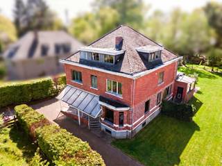 In de gegeerde residentiële villawijk Koningshof te Schoten bevindt zich dit uitzonderlijke eigendom met een rijke geschiedenis en enorm potentieel. Gelegen aan de Grote Singel 3A + 3B midden in een groene en rustige omgeving met statige dreven, biedt dit karaktervolle domein een zeldzame opportuniteit voor wie op zoek is naar een bijzonder renovatieproject met tal van mogelijkheden.<br /><br />Het pand kent een rijke maatschappelijke geschiedenis en deed in het verleden dienst als opvang- en zorginstelling.<br /><br />Het eigendom is momenteel ingericht op een zeer veelzijdige manier en biedt tal van mogelijkheden voor wonen, werken of een combinatie van beide. Dankzij de royale volumes en flexibele indeling is het pand uitermate geschikt voor:<br /><br />- combinatie wonen en vrij beroep<br />- groepspraktijk<br />- co-housing<br />- kantoorfunctie<br />- praktijk- of consultatieruimtes<br />- ....<br />Indeling :<br /><br />Het gelijkvloers bestaat uit twee zeer ruime polyvalente ruimtes, momenteel ingericht als vergaderzalen/kantoorruimtes, een ruime woonkamer met open keuken + bijkeuken/wasplaats<br />Op de eerste verdieping vind je vijf ruime kamers en twee badkamers. Ga je nog verder naar boven kom je op de tweede verdieping waar zich nogmaals vijf zeer ruime kamers bevinden met één badkamer<br /><br />De kamers zijn stuk voor stuk bijzonder ruim en kunnen flexibel ingericht worden als slaapkamers, leefruimtes, burelen, praktijkruimtes of hobbykamers.<br /><br />Daarnaast beschikt de woning over een grote, droge staankelder onder het volledige gebouw, ideaal voor stockage, archiefruimte of extra bergruimte.<br /><br />Het totale perceel beslaat maar liefst 2.951 m², inclusief het aanliggende perceel waarop zich een uiterst charmant bijhuis bevindt. Dit aparte gebouw biedt extra mogelijkheden als gastenverblijf, kantoor, atelier of zelfstandige praktijkruimte.<br /><br />Hoewel het eigendom nood heeft aan een aanzienlijke renovatie, vormt net dit de ideale basis om deze statige woning opnieuw in haar volle glorie te herstellen. De royale volumes, historische uitstraling en uitzonderlijke ligging maken van dit pand een buitenkans voor visionaire kopers die charme, karakter en potentieel weten te waarderen.<br /><br />Een werkelijk fantastische opportuniteit voor wie droomt van een prestigieus project op een toplocatie in het groene hart van Schoten.