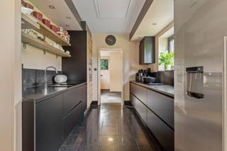 <p>Moderne, vrijstaande villa met een riante leefruimte, kantoor en prachtige tuin.</p>
<p>In een residentiële en rustige omgeving bevindt zich deze mooie, moderne vrijstaande villa, gelegen op een royaal perceel van 2.004 m² met een straatbreedte van circa 42 meter. De woning onderscheidt zich door haar ruime indeling, grote glaspartijen, duurzame materialen en veelzijdige gebruiksmogelijkheden. Dankzij de uitzonderlijk ruime bureelruimte is deze villa bijzonder geschikt voor wie comfortabel van thuis uit wil werken of een vrij beroep wenst uit te oefenen.</p>
<p>Op het gelijkvloers verwelkomt u een ruime inkomhal met Belgische blauwsteen als vloerbekleding. Links bevindt zich de trap naar de bovenverdieping en het gastentoilet met handenwasser. Achteraan bevindt zich een ruime kamer, momenteel ingericht als dressing, die de mogelijkheid biedt om een bijkomende slaapkamer te creëren. De badkamer is uitgerust met een douche en lavabomeubel. Naast de badkamer bevindt zich de slaapkamer met ingemaakte kasten en aansluitend een douchecel en lavabo. Verder zijn er nog een praktische wasplaats, een berging met de verwarmingsinstallatie, van hieruit heeft u toegang naar buiten en een inpandige garage met carport.</p>
<p>De eerste verdieping vormt het hart van de woning en biedt een bijzonder ruime en lichtrijke leefruimte, harmonieus ingedeeld in een eetplaats en een gezellige zithoek met haard. De massieve eikenhouten parket van 22 mm dik en de hoge glaspartijen over de volledige lengte zorgen voor een warme, moderne uitstraling en een overvloed aan natuurlijk licht.</p>
<p>Via een dubbele schuifdeur bereikt u het ruime terras van ongeveer 30m², afgewerkt met bankirai planken en voorzien van verlichting, een elektrisch bediende zonneluifel en een riante ijzeren draaitrap die rechtstreeks toegang geeft tot de tuin. De open keuken sluit naadloos aan op de leefruimte en geniet van een mooi uitzicht op het groen. Ze is uitgerust met boven- en onderkasten, een koelkast, oven, vaatwasser, kookplaat met geïntegreerde afzuiging en spoelbak met aansluitend de berging/bijkeuken en aparte toiletruimte.</p>
<p>Aan de linkerzijde van de woning bevindt zich een uitzonderlijk ruime bureelruimte van circa 50m². De massieve eikenhouten parket van 22 mm dik, de talrijke hoge glaspartijen en het panoramische uitzicht over de tuin en de omgeving creëren een inspirerende werkomgeving. De ruimte beschikt bovendien over een elektrische zonneluifel en airco. Deze polyvalente ruimte biedt tal van mogelijkheden voor thuiswerk, een kantoor aan huis of de uitoefening van een vrij beroep of masterbedroom.</p>
<p>Op de tweede verdieping bevindt zich een zolderruimte van circa 90 m² die nog verder afgewerkt kan worden. Hierdoor beschikt de woning over bijkomend potentieel voor uiteenlopende invullingen, afhankelijk van uw wensen en behoeften.</p>
<p>Ook buiten heeft deze villa heel wat te bieden. De mooie aangelegde en volledig omheinde tuin vormt een groene oase van rust en privacy. Naast een groot tuinhuis beschikt het perceel over een ruim overdekt terras onder de huidige bureelruimte, een serre en vijvers die bijdragen aan het karaktervolle geheel.</p>
<p>Dankzij de ruime parkeermogelijkheden aan de voorzijde, de inpandige garage, de carport en de flexibele indeling is deze villa niet alleen ideaal voor wie op zoek is naar een comfortabele gezinswoning, maar ook bijzonder interessant voor zelfstandigen of vrije beroepen die wonen en werken op één locatie willen combineren. Bovendien is er een laadpaal aanwezig aan de carport.</p>
<p>Tot slot is de volledige villa, met uitzondering van de garage, voorzien van een kruipkelder. Alle achterramen op het gelijkvloers beschikken over afsluitbare rolluiken.<br /><br />Extra info: unieke villa I deels gereoveerd in 2017 en 2020 I waterput aanwezig diepte ca. 60 meter I <span>EPC 370 kWh/ (m² jaar) label D I infoplicht: in aanvraag I watertoets: P-score: D I G-score: D.</span></p>