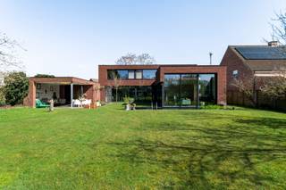 <p>Exclusieve moderne villa met zwemvijver op toplocatie (1005 m²).</p>
<p>Laat u verleiden door deze uitzonderlijke, instapklare villa waar hedendaagse architectuur, luxe en rust perfect in balans zijn. Gelegen op een ruim perceel van 1005 m² geniet u hier elke dag van volledige privacy en een adembenemend uitzicht op de prachtige tuin met zwemvijver.</p>
<p>Bij aankomst wordt u meteen gecharmeerd door de stijlvolle inkomhal met ingemaakte kasten en gastentoilet. De lichtrijke leefruimte vormt het absolute hart van de woning, met grote raampartijen die binnen en buiten naadloos in elkaar laten overvloeien en een panoramisch zicht bieden op het groen en de zwemvijver. Aansluitend vindt u een gezellige tv-hoek of bureauruimte ideaal voor ontspanning of thuiswerk.</p>
<p>De volledig ingerichte keuken met centraal eiland is volledig uitgerust en vormt een echte eyecatcher. Ze sluit perfect aan op de eetruimte, waar u geniet van een uniek zicht op de tuin. Achterliggend bevindt zich een ruime, praktische berging met alle voorzieningen.</p>
<p>Op de bovenverdieping ontdekt u een luxueuze master suite met dressing en een elegante en-suite badkamer. Daarnaast zijn er nog twee volwaardige slaapkamers met een tweede stijlvolle douchekamer. De aparte bureauruimte met zicht op de tuin maakt het plaatje compleet.</p>
<p>Buiten wordt het puur genieten: een prachtig aangelegde tuin met zwemvijver, een overdekt terras voor lange zomeravonden en een ruime tuinberging van 28 m². De carport en extra parkeergelegenheid zorgen voor optimaal comfort.</p>
<p>Een unieke woonbeleving voor wie op zoek is naar luxe, rust en verfijning.</p>
<p>Extra info: vloerverwarming I sunscreens I ventilatiesysteem C+ I hoogrendementsglas (4-seizoensglas) EPC<span> 158 kWh/(m²jaar) label B</span> I <span>infoplicht: in aanvraag I watertoets: P-score: A I G-score: A.</span></p>
<p></p>
