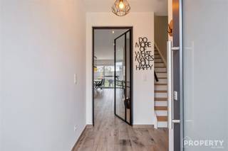 Indeling: inkomhal met gastentoilet, open leefruimte met inbouwhaard, open keuken met keukeneiland en voorzien van alle toestellen. Ruime garage.Op...