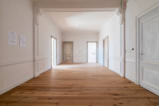 <p><em><strong>Wonen in een beschermd monument, met het comfort van vandaag</strong></em><br />In het hart van Turnhout krijgt één van de meest iconische herenhuizen van de stad een nieuw hoofdstuk. Residentie Het Gerecht is de stijlvolle renovatie van het voormalige Huis Van Hal, een beschermd neoclassicistisch monument uit 1886, ontworpen door architect Pieter-Jozef Taeymans.</p>
<p>Doorheen de jaren deed het gebouw dienst als privéwoning, arbeidsrechtbank en later als decor van het VTM-programma Mijn Pop-Up Restaurant. Vandaag wordt dit uitzonderlijke erfgoed met respect gerestaureerd en omgevormd tot een exclusieve residentie met slechts vier royale villa-appartementen.</p>
<p>Authentieke elementen worden zorgvuldig hersteld, terwijl moderne technieken, hedendaags comfort en een lift discreet worden geïntegreerd. Elk appartement beslaat een volledige verdieping en biedt maximale rust, privacy en ruimte.<br /><br /><strong><em>Het villa appartement op de tweede verdieping</em> <br /></strong>Dit appartement biedt bijna 210m² aan royale woonoppervlakte<strong>.</strong> De ruimte die we typisch zouden benoemen als “inkomhal” is dermate groot dat deze ruimte eveneens geschikt is als ontspanningsruimte, bureau, of 2<sup>e</sup> zithoek. De leefkeuken, eetkamer en zithoek staan met elkaar in verbinding en genieten langs 2 zijden van natuurlijk daglicht. Openslaande deuren geven uit op een heerlijk privaat terras aan de achterzijde, met daar een mooi uitzicht over een magnolia en de historische gebouwen van het Heilig Graf. De hoofdslaapkamer heeft een ensuite badkamer, de 2 overige slaapkamers delen de 2e badkamer.</p>
<p>Iedere eigenaar beschikt over een private kelderberging (27 tot 39 m²). Daarnaast blijven de historische wijnkelder en authentieke kolenkelder als gemeenschappelijke ruimtes behouden. De lift brengt u bovendien tot in de kelder.</p>
<p>Parkeren doet u onder uw private dubbele carport met aansluitende fietsenstalling. Daarnaast is een gemeenschappelijke afvalberging voorzien.<br /><br /><em><strong>Een hoogwaardige afwerking<br /></strong></em>Het appartement wordt volledig afgewerkt opgeleverd, met uitzondering van de definitieve schilderwerken. Een nieuwe parketvloer is al geplaatst, en ook de muren en plafonds worden gerestaureerd en alles krijgt reeds een eerste schilderlaag. Voor de keuken en badkamers kiest u zelf de materialen en inrichting. Hiervoor zijn ruime budgetten in de vraagprijs opgenomen.</p>
<p>Ook technisch wordt alles vernieuwd. Het appartement wordt voorzien van domotica, vloerverwarming, een Viessmann-warmtepomp, ventilatie D en voorbereidingen voor een gashaard. Zo geniet u van hedendaags comfort met behoud van het historische karakter.</p>
<p>Het appartement en de kelderberging worden verkocht onder registratierechten (2% of 12%). <br />Op de dubbele carport met fietsenberging is 21% btw van toepassing.</p>
<p>De restauratiewerken zijn volop aan de gang. De oplevering wordt verwacht rond het najaar van 2026.</p>
<p><strong>Een beschermd monument, slechts vier exclusieve villa-appartementen en een penthouse dat zijn gelijke in Turnhout nauwelijks kent.<br /></strong></p>