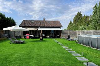 Ontdek deze verrassend ruime bungalow met extra gastenverblijf, hobbyruimte of kantoor, gunstig gelegen langs de N70 in Melsele, op wandelafstand van tram en bus.De woning biedt een royale leefruimte, grote ingerichte keuken, 2 slaapkamers en een badkamer op het gelijkvloers en een grote, ingerichte zolderverdieping van maar liefst 90 m², bereikbaar via een vaste trap en ingericht als twee bijkomende kamers. De woning is instapklaar, terwijl eventuele modernisering volledig op uw tempo kan gebeuren.In de prachtige zuidgerichte tuin geniet u de hele dag van de zon. Het ruime terras, uitgerust met een elektrische zonnetent, vormt de perfecte plek om te ontspannen.De woning is voorzien van centrale verwarming op mazout, dubbel glas en elektrische rolluiken. De recent vernieuwde badkamer is een extra troef.Achteraan het perceel bevindt zich een volledig ingericht gastenverblijf met leefruimte, open keuken, badkamer met washoek, apart toilet en slaapkamer — ideaal voor bezoekers, zelfstandigen of hobby’s.Vooraan wordt bovendien een nieuwe parkeerzone aangelegd.Laat u verrassen door de vele mogelijkheden van deze eigendom en plan snel uw bezoek via dewaele.com.