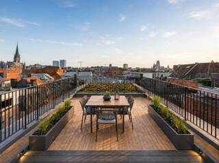 <h2><span>LUXE DUPLEX APPARTEMENT </span></h2><h2><span>MET ROYALE TERRASSEN, UNIEK SKYLINEZICHT MET PANORAMISCH ZICHT</span></h2><h2><span>OP TOPLOCATIE AAN HET EILANDJE</span></h2><p><span>Op een Toplocatie aan het </span><span>Eilandje te Antwerpen</span><span>, bevindt zich deze uitzonderlijke duplex. </span></p><p><span>Een woonst waar architectuur, ruimte en verfijning samenkomen, met als absolute troef de </span><span>royale terrassen aan zowel de voor- als achterzijde met zicht op de Antwerpse Skyline</span><span>.</span></p><p><span>Zachte aardetinten, warme houtaccenten en zichtbare betonnen structuur-elementen creëren een tijdloze en serene sfeer.</span></p><h3><span>4e VERDIEP: Comfort in rust en ruimte</span></h3><p><span>Hier bevindt zich de </span><span>royale leefruimte</span><span>, waar grote raampartijen voor een overvloed aan natuurlijk licht zorgen. De open architectuur en warme materialen geven deze ruimte een uitgesproken karakter.</span></p><p><span>De</span><span> 2 slaapkamers</span><span> hebben een gedeeld terras en bieden een rustige sfeer. De </span><span>badkamer </span><span>werd in dezelfde stijl afgewerkt, met een dubbele wastafel. </span><span>Apart gastentoilet.</span></p><h3><span>5e VERDIEP: Koken, tafelen en genieten</span></h3><p><span>Via de </span><span>interne trap </span><span>naar de bovenste verdieping, bevindt zich de </span><span>ruime open keuken en eetruimte</span><span>. Aanpalend een </span><span>Riante bergruimte</span><span> voorzien en </span><span>apart gastentoilet.</span></p><p><span>Maatwerkkeuken van de gespecialiseerde keuken- en kastenbouwer MANAS, </span><span>deze combineert lichte houten fronten met hoogwaardige werkbladen, geïntegreerde toestellen en een royaal kookeiland.</span></p><p><span>De keuze om de keuken op de bovenste verdieping onder te brengen, komt hier volledig tot zijn recht. Vanuit deze ruimte is er een directe verbinding met de buitenruimte, waardoor koken en tafelen naadloos overgaan in het buitenleven. </span></p><p><span>De duplex beschikt over </span><span>ruime terrassen aan zowel de voor- als achterzijde</span><span>. Hierdoor kunt u op verschillende momenten van de dag van zon, rust en uitzicht genieten. Er is meer dan voldoende plaats voor zowel een volwaardige eettafel en loungegedeelte.</span></p><p><span>Met de Antwerpse daken en skyline als decor vormen de terrassen een uitzonderlijke plek voor lange zomeravonden, diners met vrienden of simpelweg een rustig moment boven de stad.</span></p><p><span>Het Eilandje, het MAS, de Scheldekaaien en het historische centrum</span><span> bevinden zich op wandelafstand, terwijl u thuis geniet van ruimte, privacy en uitzonderlijke buitenruimte. </span></p><p><span> </span></p><p><span>MOGELIJKEHEID AANKOOP DUBBELE AUTOSTAANPLAATS.</span></p><p><span>MOGELIJKHEID AANKOOP PRIVATIEVE KELDER(S) €8.250 - €12.000 gaande van 12M² - 18M²</span></p><p><span> </span></p><p><span>TROEVEN:</span></p><ul><li><span>Hoogwaardige materialen</span></li><li><span>LIFT met uitgang op verdiep en in het appartement zelf, ook tot -1</span></li></ul><ul><li><span>Zicht op groen (straatkant)</span></li><li><span>Breed en Lichtrijk appartement</span></li><li><span>Gemeenschappelijke fietsenberging</span></li><li><span>Nabij Eilandje, Winkels, Restaurants, Uitvalswegen, Fitness Centra, ... </span></li></ul><ul><li><span>Mobiscore 9,5/10</span></li><li><span>Volledig instapklaar (Nieuwbouw staat)</span></li><li><span>Toplocatie</span></li><li><span>Keuzemogelijkheden Keuken en Badkamer (mogelijk in deze fase)</span></li><li><span>EPC label A</span></li><li><span>Privatieve Zonnepanelen 1500Wp</span></li></ul><p><span> </span></p><p><span>Een zeldzame duplex die het gevoel van een stadswoning combineert met het comfort van een hoogwaardig appartement: royale leefruimtes beneden, koken en tafelen boven, twee prachtige terrassen en Antwerpen als decor.</span></p><p><span> </span></p><p><span> </span></p><p><span> </span></p>