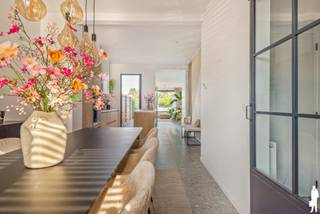<p><strong>Smaakvol gerenoveerde woning met 3 slaapkamers en mooie tuin</strong></p>
<p>In het centrum van Duffel vinden we deze bijzonder charmante woning die in 2023 van A tot Z werd gerenoveerd, met veel aandacht voor kwaliteit, comfort en esthetiek. Achter de karaktervolle gevel schuilt een verrassend stijlvol interieur met een prachtige lichtinval.</p>
<p>De doordachte indeling, de hoogwaardige afwerking en de aangename verbinding met de tuin maken van deze woning een heerlijke plek om thuis te komen.</p>
<p><strong>Algemeen:</strong></p>
<ul>
<li>Totaalrenovatie in 2023, inclusief achterbouw</li>
<li>Bewoonbare oppervlakte van ca. 133 m²</li>
<li>Perceel van 177 m²</li>
<li>Nieuwe ramen met dubbele beglazing en vernieuwd, geïsoleerd dak</li>
<li>3 volwaardige slaapkamers</li>
<li>Prachtige open keuken met Siemens-inbouwtoestellen</li>
<li>Ruime badkamer met ligbad, inloopdouche en dubbele wastafel</li>
<li>2 afzonderlijke toiletten</li>
<li>EPC B (197 kWh/m²) en elektrische installatie conform</li>
<li>Centrale verwarming op aardgas</li>
<li>Droge kelder van ca. 19 m²</li>
<li>Gezellig tuin met mooi terras</li>
<li>Ruime tuin- en fietsenberging van ca. 31 m² met achterliggende servitudeweg</li>
</ul>
<p><strong>Indeling:<br /></strong>Bij het betreden van de woning word je meteen verwelkomd door een warm en stijlvol interieur. De inkomhal met gastentoilet leidt naar de lichtrijke eetkamer aan de voorzijde.</p>
<p>Centraal in de woning bevindt zich de open keuken, die met haar warme houten kasten en centraal eiland een echte blikvanger vormt. De keuken is volledig ingericht met kwalitatieve Siemens-toestellen en vormt de perfecte verbinding tussen de eetkamer en de achterliggende leefruimte.</p>
<p>De gezellige zithoek geniet dankzij het grote raam van een mooie lichtinval en een rustgevend zicht op de tuin. De verschillende leefruimtes vloeien op een natuurlijke manier in elkaar over en creëren zo een harmonieus geheel waarin gezelligheid en hedendaags wooncomfort centraal staan.</p>
<p>Op de <strong>eerste verdieping</strong> bevindt zich een ruime slaapkamer (ca. 17m²), een afzonderlijk toilet en de bijzonder smaakvol ingerichte badkamer. Deze laatste beschikt over een vrijstaand ligbad, een ruime inloopdouche en een dubbel lavabomeubel. De verfijnde afwerking geeft de ruimte een heerlijk ontspannen uitstraling.</p>
<p>De <strong>tweede verdieping</strong> omvat nog twee volwaardige slaapkamers (ca. 12 en 17m²), beide met een aangename lichtinval en een warme parketvloer. Deze ruimtes lenen zich perfect als slaapkamers, maar kunnen uiteraard ook dienstdoen als bureau of hobbyruimte.</p>
<p>Ook buiten is het volop genieten. De diepe, afgesloten tuin biedt een aangename combinatie van groen en ontspanning. Het terras aansluitend aan de woning vormt een fijne plek om buiten te tafelen, terwijl het gezellige houten terras achteraan uitnodigt om in alle rust van de tuin en de avondzon te genieten.</p>
<p>Een bijkomende troef is de ruime tuin- en fietsenberging van ca. 31 m². Dankzij de achterliggende servitudeweg is deze bovendien vlot bereikbaar met de fiets, bijzonder praktisch voor dagelijks gebruik.</p>
<p>Verder beschikt de woning over een droge kelder van ca. 19 m², ideaal als extra opslagruimte.</p>
<p><strong>Ligging:<br /></strong>De woning is gelegen in het centrum van Duffel, op een centrale locatie met winkels, scholen en andere dagelijkse voorzieningen in de omgeving. Oprit naar belangrijke verbindingswegen, de fiets-o-strade alsook het treinstation van Duffel is in de directe nabijheid.</p>