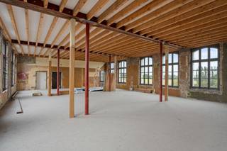 In het beschermde Frans Klooster in Wortegem-Petegem wacht een unieke woonkans: een casco-appartement van ca. 190 m² met een zuidwestgericht terras en een panoramisch zicht over de Royal Golf Club Oudenaarde. De charme van dit historische gebouw is onmiddellijk voelbaar. Authentieke muren in zichtbaar metselwerk, robuuste houten spanten en hoge plafonds vormen een karaktervol kader voor wie houdt van ruimte en authenticiteit. De vele ramen brengen het licht en de omliggende natuur overvloedig naar binnen.
Het appartement wordt verkocht in volledig casco-staat waardoor de koper alle vrijheid heeft om de indeling, materialen en sfeer volledig naar eigen smaak te bepalen. Denk aan een ruime leefruimte met open keuken, twee tot drie slaapkamers, of een werkplek met zicht op het groen.
De ligging is uitzonderlijk: midden in het groen, tegenover het kasteel en de golfbanen en tegelijk vlot bereikbaar vanuit Oudenaarde, Gent en Kortrijk.
Een unieke combinatie van erfgoed, rust en vrijheid, waar verleden en toekomst elkaar ontmoeten.
Voor meer info of een bezoek ter plaatse, contacteer Stijn via 0493 02 99 68 of via stijn@altro-vastgoed.be