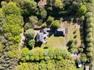 Wie op zoek is naar ruimte, rust en veelzijdigheid, voelt zich hier meteen thuis. Deze uitzonderlijke vrijstaande woning is gelegen op een prachtig perceel van maar liefst 8.392 m² en combineert royale volumes met privacy, comfort en een uniek groen kader.<br /><br />De woning wordt omgeven door een schitterende, volwassen en perfect georiënteerde zuidgerichte tuin, waar je in alle rust geniet van zon, natuur en een weids uitzicht op het omliggende groen. De ruime oprit en garage zorgen bovendien voor optimaal praktisch comfort en voldoende parkeergelegenheid.<br /><br />Binnen verwelkomt de woning je met bijzonder royale leefvolumes en een doordachte indeling. <br />De woning beschikt over 4 bijzonder ruime slaapkamers, elk met veel lichtinval en tal van indelingsmogelijkheden. De badkamer is volledig uitgerust en biedt alle comfort met zowel een ligbad als een douche.<br /><br />Een extra troef is de ruime zolderverdieping, bereikbaar via een vaste trap. Deze polyvalente ruimte biedt nog tal van mogelijkheden en kan perfect ingericht worden als extra slaapkamers, hobbyruimte, bureau of ontspanningsruimte.<br /><br />De inpandige dubbele garage heeft nog een bijkomende zolder die ook nog volledig ingericht kan worden. <br /><br />Naast het hoofdgebouw is er nog een bijgebouw dat volledig voorzien is van keuken en badkamer en mogelijkheid bied voor uitbreiding van 1 naar 3 slaapkamers. <br /><br />Dit eigendom biedt een uitzonderlijke flexibiliteit en is ze uitermate geschikt voor cohousing, kangoeroewonen, een praktijk aan huis of het comfortabel samenwonen van meerdere generaties.<br /><br />Daarnaast biedt deze woning ook energetisch nog interessante opportuniteiten: met een beperkte investering kan het EPC aanzienlijk verbeterd worden. Bij de plaatsing van een warmtepomp en het verwijderen van de houtkachel kan de EPC-score stijgen naar begin label B, wat een mooie meerwaarde betekent voor de toekomstige eigenaar.<br /><br />Contacteer Vincent voor een bezoek ter plaatse via 0475 21 00 86 of Vincent@reds.be.