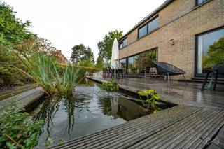 <p>In de rust van het dorp Bossut, in de onmiddellijke nabijheid van het centrum van Grez-Doiceau, verleidt deze mooie woning door haar royale volumes, haar comfort en een uitzonderlijke buitenruimte.</p>
<p>In het hart van de woning verenigt een immense open leefruimte de keuken, de eetkamer en een gezellige salon met een open haard — een lichtrijke en gezellige ruimte, bedacht voor het gezinsleven en om te ontvangen.</p>
<p>Op de verdieping biedt de woning drie slaapkamers en een badkamer, terwijl een mooi bureau, ingericht op een halve verdieping, eenvoudig als bijkomende slaapkamer kan dienen. De tweede verdieping onthult op haar beurt een ruim nachtgedeelte met een hal, een badkamer en de laatste slaapkamer — een mooi geheel, ruim en moduleerbaar naargelang de levensprojecten.</p>
<p>Buiten onthult de woning al haar charme. Een groot terras van 120 m² ontvouwt zich rond een vijver, wat een rustig en uniek kader creëert, en vervolgens, op een tweede niveau, nodigt een verwarmd zwembad op warmtepomp, eveneens omringd door zijn terras, uit tot ontspanning gedurende het hele mooie seizoen.</p>
<p>De woning beschikt ten slotte over een kelder over de volledige oppervlakte, met twee garages met elektrische poorten en twee kelders. Verschillende parkeerplaatsen vervolledigen nog het geheel.</p>
<p>Ruimte, lichtinval, comfort en een betoverende buitenruimte : een zeldzame gezinswoning, in een van de mooiste dorpen van de entiteit. EPC C.</p>
