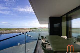 Op zoek naar een <strong>stijlvol gemeubeld appartement te huur in Oostende met zicht op zee en de duinen</strong>?<br /><br />Dit prachtig appartement in <strong>Residentie Trinity, gelegen aan de populaire Oosteroever in Oostende</strong>, combineert ruimte, comfort en een uitzonderlijke ligging aan de Belgische kust.<br /><br />Het appartement bevindt zich op de <strong>3de verdieping</strong> en beschikt over een royale woonoppervlakte van <strong>131 m²</strong>, aangevuld met een indrukwekkend <strong>terras van ca. 30 m²</strong> aan de voorzijde.<br />Vanop het terras en vanuit de woonkamer geniet u van een <strong>uniek en prachtig zicht op de zee en de duinen</strong>.<br /><br /><strong>Ruime woonkamer met open keuken</strong><br />De lichtrijke woonkamer vormt het hart van het appartement en biedt dankzij de grote raampartijen een bijzonder aangenaam uitzicht.<br />De <strong>open keuken is volledig ingericht</strong> en sluit naadloos aan op de leefruimte, ideaal voor comfortabel wonen en gezellig tafelen.<br /><br /><strong>Twee slaapkamers, slaaphoek en twee badkamers</strong><br />Het appartement beschikt over een ruime <strong>masterbedroom met dressing en eigen badkamer</strong>, uitgerust met een <strong>ligbad, douche, lavabo en toilet</strong>.<br />Daarnaast is er een <strong>tweede slaapkamer en een afzonderlijke slaaphoek</strong>, met een extra badkamer voorzien van een <strong>douche en lavabo</strong>. Verder beschikt het appartement over een <strong>afzonderlijk toilet</strong> en een praktische <strong>berging met wasmachine</strong>.<br /><br /><strong>Troeven van dit gemeubeld appartement</strong><br /><span>Gemeubeld appartement in <strong>Residentie Trinity – Oosteroever Oostende</strong></span><br /><span><strong>Uniek zicht op zee en de duinen</strong></span><br /><span>Bewoonbare oppervlakte van <strong>131 m² + groot terras van 30 m²</strong></span><br /><span><strong>EPC: slechts 33 kWh/m²</strong>, zeer energiezuinig</span><br /><span>Verwarming via <strong>warmtenet</strong></span><br /><span>Mogelijkheid tot het huren van een parking in de directe omgeving: <strong>€ 125/maand</strong></span><br /><span>Provisie vaste kosten: <strong>€ 150/maand</strong></span><br /><span><strong>Onmiddellijk beschikbaar</strong></span><br /><br />Dit <strong>gemeubeld appartement met zeezicht in Oostende</strong> is een uitstekende keuze voor wie comfortabel en stijlvol wil wonen aan de kust, op een bijzondere locatie in de <strong>Oosteroever</strong>.<br /> 