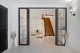<p><span>Deze statige voormalige dokterswoning combineert grandeur, ruimte en hedendaags wooncomfort op een uitzonderlijke manier. De woning werd recent volledig gerenoveerd en biedt tal van mogelijkheden voor grote gezinnen, een kangoeroewoning of het combineren van wonen en werken.</span></p><p><span>Op het gelijkvloers bevindt zich een volledig afzonderlijk woongedeelte, ideaal voor inwonende ouders, kinderen of gasten. Dit private gedeelte beschikt over een eigen keuken, een gezellige leefruimte, twee slaapkamers en een gastentoilet. Aansluitend vindt u een ruime polyvalente ruimte die perfect kan dienen als hobbyruimte, praktijkruimte, atelier of opslagplaats. Deze ruimte bevindt zich naast de dubbele inpandige garage.</span></p><p><span>De volledige woning is bovendien onderkelderd, wat zorgt voor een enorme hoeveelheid extra bergruimte en tal van mogelijkheden.</span></p><p><span>Vanaf de eerste verdieping start de hoofdwoning. Hier wordt u onmiddellijk verwelkomd door een indrukwekkende leefruimte met prachtige hoge plafonds en een stijlvolle parketvloer die de authentieke charme van de woning perfect in de verf zet.</span></p><p><span>Achter de living bevindt zich de luxueuze leefkeuken, uitgerust met een royaal kookeiland en voorzien van alle moderne toestellen. De ingebouwde koelkast met geïntegreerd ledscherm vormt een echte blikvanger. Via het grote schuifraam heeft u rechtstreeks toegang tot het ruime dakterras met westelijke oriëntatie, waar u elke avond kunt genieten van een prachtige zonsondergang. Op deze verdieping bevindt zich eveneens een tweede gastentoilet.</span></p><p><span>De tweede verdieping biedt alle comfort voor het moderne gezin. Er is een praktische wasruimte voorzien voor wasmachine en droogkast, evenals een ruime badkamer uitgerust met een ligbad, douche en toilet. Aan de voorzijde van de woning bevinden zich drie ruime slaapkamers, terwijl aan de zijgevel de royale master bedroom is gelegen. Deze beschikt over een eigen en suite badkamer met dubbele lavabo, ligbad en toilet.</span></p><p><span>Verder werd de woning uitgerust met nieuwe aluminium ramen en automatische rolluiken aan alle ramen, wat zorgt voor extra comfort, veiligheid en energiezuinigheid.</span></p><p><span>De woning is gelegen nabij het Jan Palfijn ziekenhuis.</span></p>