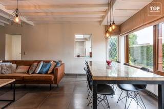 Deze halfopen bebouwing is gelegen op een bijzonder aangename en groene locatie in Drongen, waar rust en privacy centraal staan. <br /><br />Tegelijk bevinden winkels, scholen en belangrijke invalswegen zich op korte afstand, waardoor de woning een uitstekende combinatie biedt van rustig wonen en een vlotte bereikbaarheid.<br /><br />De woning werd in het verleden uitgebaat als B&amp;B en beschikt over vier volwaardige slaapkamers, elk voorzien van eigen sanitair met douche, toilet en airconditioning.<br /><br />De indeling biedt hierdoor heel wat mogelijkheden voor een gezin, maar eveneens voor wie extra ruimte zoekt voor gasten, thuiswerk of een andere invulling.<br /><br />De keuken sluit aan op de praktische wasplaats, met aansluitend een riante garage die momenteel voornamelijk als bergruimte wordt gebruikt en heel wat opslagmogelijkheden biedt.<br /><br />Buiten geniet u van een gezellige, groene tuin met veel privacy.<br /><br />De afgesloten oprit met poort versterkt het private karakter van het perceel en biedt voldoende parkeermogelijkheden.<br /><br />Een veelzijdige woning op een groene toplocatie in Drongen, met vier slaapkamers, veel privacy en alle dagelijkse voorzieningen binnen handbereik.<br /><br />Bel Top Vastgoed voor een bezoek op 0475 700 700