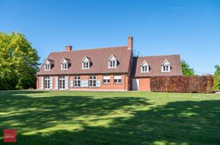 Ruime villa naar de hand van architect Jacques Viérin, bestaande uit inkomhal, living met open haard en parket, eetplaats, keuken, wasplaats, bureel, 5 slaapkamers, 2 badkamers, kelders (ongeveer helft van huis onderkelderd), zolder en dubbele garage. De woning is goed geïsoleerd, en mits aanpassing verwarming (momenteel elektrisch systeem 'Masser') kan deze een goede EPC behalen. Tuin op ca. 2.800m² met mogelijkheid deel tuin (perceel bouwgrond van +/- 25m x 70m =+/- 1.750m²) bij te kopen.