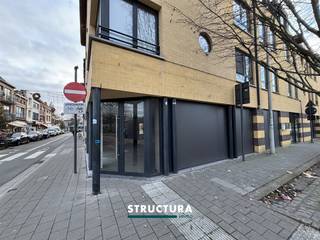 COMMERCIEEL KANTOORRUIMTE IN AALSTDeze moderne kantoorruimte van 120m² is gevestigd in het hart van Aalst, op een uitstekende locatie in het stadscentrum. Het pand bevindt zich op de begane grond van een gebouw met een opvallende gevel in baksteen en donkere accenten.LIGGING EN BEREIKBAARHEIDHet kantoor geniet van een prima positie aan een drukke winkelstraat in Aalst, wat uitermate geschikt is voor bedrijven die zichtbaarheid en voetgangersdoorstroming nastreven. De locatie biedt directe toegang vanuit de straat en beschikt over grote raampartijen die zorgen voor maximale etalagepresentatie en natuurlijk licht.RUIMTE EN LAY-OUTDe kantoorruimte biedt een open en flexible indeling met een totale oppervlakte van 120m². Het interieur beschikt over enkele voorgemaakte ruimtes, waaronder faciliteiten met toilet en wastafel. De ruime vloeroppervlakte met tegelvloer en afgewerkt plafond biedt volledige vrijheid voor verschillende inrichtingen afhankelijk van uw bedrijfsbehoeften.VOORZIENINGENHet pand is voorzien van praktische sanaire voorzieningen ter plaatse. De moderne afwerking met vast inrichting toont dat dit een professioneel ingericht kantoorruimte betreft, klaar voor onmiddellijke bedrijfsvoering of verdere aanpassingen naar wens.Dit kantoor is perfect geschikt voor diverse commerciële activiteiten, detailhandelszaken, kantoren of servicebedrijven die baat hebben bij een prominente locatie in het stadscentrum van Aalst.