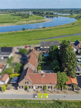 <strong>KARAKTERVOLLE WONING MET 2 VERGUNDE WOONENTITEITEN OP UNIEKE LIGGING AAN DE MAAS TE STOKKEM.</strong><br /><br /><strong>TROEVEN</strong><br />- Rustige en unieke ligging nabij de Maas, natuur en wandelroutes.<br />- 2 Officiële postbussen.<br />- Ideale zorg of kangoeroe woning.<br />- Vergunde 2 woonentiteiten.<br />- Vele belangrijke vernieuwingen.<br />- Vele mogelijkheden voor grote gezinnen, zelfstandigen of combinatie wonen/werken.<br />- Ruim perceel van 12a63ca.<br />- Energielabel C. <br />- Elektrische installatie conform vernieuwd.<br />- Voldoende parkeergelegenheid op eigen terrein.<br /><br /><strong>KELDERVERDIEPING</strong><br />Gewelfde kruipkelder (beperkte ruimte).<br /><br /><strong>GELIJKVLOERS WOONENTITEIT 1</strong><br />Inkomhal (1,15m x 7,90m = 9,09m²): tegelvloer.<br />Toilet: tegelvloer.<br />Woonkamer (4,25m x 6,65m = 28,26m²): tegelvloer.<br />Keuken +veranda (8,60m x 3,00m+ 6,75m x 6,65m = 70,69m²): aansluitingen keukenvoorziening aanwezig, tegelvloer.<br /><br /><strong>GELIJKVLOERS WOONENTITEIT 2</strong><br />Woonkamer (4,65m x 4,50m + 3,30m x 3,00m = 30,83m²): parketvloer.<br />Keuken (4,50m x 4,50m = 20,25m²): geïnstalleerd met onder- en bovenkasten, lades, heteluchtoven, keramische kookplaat, tegelvloer.<br />Berging (3,00m x 3,25m = 9,75m²): cv ruimte, tegelvloer.<br />Badkamer (3,00m x 3,25m = 9,75m²): geïnstalleerd met enkele lavabo, kolomkasten, douche en toilet, tegelvloer.<br /><br /><strong>VERDIEPING +01</strong><br />Open ruimtes staan in verbinding met de 2 woningen, momenteel naar keuze in te delen:<br />Ruimte 1 (11,30m x 5,65m = 63,85m²): momenteel ingericht als slaapkamer, badkamer en berging, plankenvloer.<br />Ruimte 2 (10,85m x 5,50m = 59,68m²): plankenvloer.<br /><br /><strong>EXTERIEUR</strong><br />Garage + carport.<br />Werkplaats + carport.<br />Rustige, omheinde tuin met veel privacy.<br /><br /><strong>RENOVATIES</strong><br />1999-2005 (Vergunning 2 woonentiteiten= totaalrenovatie 2 woningen): elektriciteit, sanitair en leidingwerk, interieur, dak en isolatie, voegwerken gevel.<br />2022: hardhout ramen en deuren, keuken woonentiteit 2.<br /><br />Bekijkt u deze advertentie via een aanverwante vastgoedsite, surf dan zeker naar onze website voor een uitgebreide beschrijving en foto's. Meer info: +32 (0)89 86 18 88 of info@N78vastgoed.be.