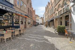 Droomt u van een eigen horecazaak op een absolute A-locatie? Dit unieke horecapand te huur in Brugge bevindt zich in de bruisende Sint-Amandsstraat, op een steenworp afstand van de historische Markt Brugge. Indeling en troeven van dit horecapand:Gelijkvloers commerciële ruimte:Een indrukwekkende en lichte ruime verbruikszaal (107m²), perfect afgewerkt met een warme parketvloer.Achteraan bevindt zich een keuken (8,5m²) niet ingericht, een functionele berging (15m²), een toilet en een koer.Het pand is volledig onderkelderd, wat zorgt voor uitzonderlijk veel opslagruimte.Eerste verdieping (woonst boven horeca):Via de overloop (20m²) bereikt u de private residentiële ruimte.Een lichte living met open keuken (36m²).Een ruime kamer (28m²).Badkamer uitgerust met douche en lavabo, plus een apart toilet.Tweede verdieping:Een ruime zolder die nog tal van inrichtingsmogelijkheden biedt.Dit pand is gelegen op een toplocatie toplocatie met een constante toestroom van lokale passanten en toeristen.