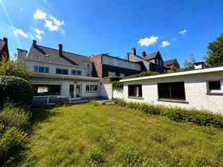 Op een toplocatie in de hoofdstraat van Ertvelde, waar slechts zelden woningen op de markt komen, bevindt zich deze karaktervolle en instapklare eigendom. Met een bewoonbare oppervlakte van maar liefst 340 m² en een prachtig perceel van 1.445 m² biedt deze woning een unieke combinatie van ruimte, charme en talloze mogelijkheden.<br /><br />De woning werd doorheen de jaren met de grootste zorg onderhouden, zowel binnen als buiten. Authentieke elementen, prachtig maatwerk en een warme, unieke uitstraling zorgen voor een bijzonder aangename sfeer. Dankzij de flexibele indeling leent deze eigendom zich perfect voor grote gezinnen, een combinatie van wonen en werken of het creëren van extra slaapkamers. Momenteel beschikt de woning over vier volwaardige slaapkamers, met de mogelijkheid om uit te breiden naar zes of zelfs zeven slaapkamers. De voormalige apotheek biedt bovendien een uitstekende opportuniteit voor een praktijkruimte, kantoor of vrij beroep.<br /><br />De oorspronkelijke keuken en badkamer bieden de nieuwe eigenaar de kans om deze volledig naar eigen smaak te moderniseren, terwijl de rest van de woning onmiddellijk bewoonbaar is. De recente cv-ketel op aardgas zorgt voor een efficiënte verwarming en dankzij de aanwezigheid van twee betonnen gewelven geniet u van een bijzonder stevige constructie.<br /><br />Verder beschikt de woning over een praktische wijnkelder van ongeveer 22 m², een inpandige garage met doorgang naar de tuin en een vaste trap naar de tweede verdieping, die nog extra mogelijkheden biedt.<br /><br />Achteraan wacht een absolute troef: een uitzonderlijk diepe, zonnige en groene tuin waar rust en privacy centraal staan. De tuin beschikt bovendien over een praktische berging en geeft de woning het gevoel van een halfopen bebouwing dankzij de doorgang naast de woning.<br /><br />Bent u op zoek naar een karaktervolle woning met veel ruimte, een uitzonderlijk perceel en eindeloze mogelijkheden op een gegeerde locatie? Dan is deze unieke eigendom in Ertvelde zonder twijfel een bezoek waard.