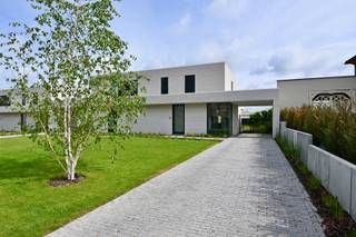 We vinden deze uitzonderlijke nieuwbouwwoning in de rustige Orgelstraat te Wilderen. De woning werd opgetrokken in 2025 en opgeleverd begin 2026 met veel aandacht voor architectuur, comfort, energiezuinigheid en duurzaamheid. Deze halfopen bebouwing maakt deel uit van een kleinschalig project waarbij strakke lijnen, gecombineerd worden met warme, kwalitatieve materialen. De grote raampartijen zorgen voor veel natuurlijke lichtinval mede dankzij de open, elegante ruimtes.<br /><br />We betreden de woning via de ruime inkomhal, met vestiairevoorzieningen, en een apart gastentoilet. Van bij het binnenkomen krijgen we reeds een ruime blik op de grote leefruimte, voorzien van prachtige grote, lichte tegels. Deze is ingedeeld met een bureauhoek aan de voorzijde van de woning - ideaal voor de thuiswerker - een zithoek, alsook een eetkamer. Verder vinden we er de volledig, ingerichte en open keuken, die het hart vormt van deze woonkamer.<br /><br />De keuken, gekenmerkt door de terugkerende strakke lijnen van de woning en de warme materialen, is volledig geïnstalleerd met kwalitatieve toestellen zoals een inductiekookplaat met geïntegreerde afzuiging, een combi-oven, een koelkast, een diepvries, alsook een afwasmachine en indirecte verlichting.<br /><br />De berging met alle aansluitingen om tevens als wasplaats te fungeren, is zeer ruim en biedt heel wat opbergmogelijkheden. We vinden er de waterverzachter, de elektrische installatie, het ventilatiesysteem (D) en de Viessmann-warmtepomp.<br /><br />Heel de benedenverdieping werd aan de achtergevel voorzien van grote glaspartijen, waardoor de leefruimten naadloos overgaan in het overdekt terras en de aangelegde tuin.<br /><br />De open trap brengt ons op de eerste verdieping die ingericht is met een centrale nachthal, drie volwaardige slaapkamers met parket en een ingericht badkamer. Deze is voorzien van een grote inloopdouche, een volwaardig lavabomeubel alsook een toilet.<br /><br />De woning is voorzien van vloerverwarming (aangesloten op de warmtepomp) alsook airco-units in elke ruimte, om zowel te koelen als te warmen. De woning beschikt over een PV-installatie (zonnepanelen) met een piekvermogen van 4,5kW alsook een regenwaterput van 10.000L aangesloten op de toiletten en buitenkranen, ideaal voor het hele gezin.<br /><br />Het perceel van 6a 39ca werd volledig omheind met zwarte draad en de tuin werd aangelegd met een stijlvolle afwerking, volledig in lijn van de woning. De combinatie van diverse afwerkingstechnieken, moderne materialen alsook beplantingen zoals meerstammige boompjes, en de bijkomende tuinverlichting zorgt voor een speelse toets. In de achtertuin bevindt zich een ruim tuinhuis, ideaal voor het bergen van tuinmeubelen, grasmachine enzovoort. De voortuin is voorzien van een carport, alsook kunnen er nog drie extra wagens geparkeerd worden.<br /><br />De woning wordt volledig geverfd verkocht inclusief heel wat roerende goederen zoals:
<ul>
	<li>nieuwe gordijnen in de gehele woning,</li>
	<li>op maat gemaakte vliegenramen,</li>
	<li>windscherm aan het terras,</li>
	<li>tuinmateriaal zoals grasmachine en robotmaaier</li>
	<li>volledige slaapkamer</li>
	<li>salon</li>
	<li>...</li>
</ul>
De woning wordt verkocht onder het stelsel van de verkooprechten.<br /><br />Heeft u interesse in deze knappe nieuwbouwwoning? Aarzel dan niet en bel ons snel op 011 70 70 19.