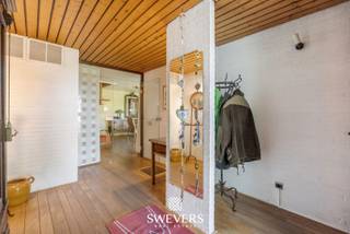 Voor meer info en foto’s, surf naar www.swevers.be – In een rustige, groene buurt van Houthalen-Helchteren vind je deze charmante open bebouwing met volledige privacy op een perceel van 10a 46ca. De woning uit 1974 met vernieuwde bovenverdieping (1988) telt 195m² bewoonbare oppervlakte en biedt ruimte aan vijf slaapkamers, twee badkamers, meerdere terrassen en een mooi aangelegde tuin rondom. De leefruimte van 60 m² met zitkuil en parketvloer sluit naadloos aan op de recente keuken. Daarnaast zijn er drie slaapkamers, een badkamer, een garage en wasplaats op het gelijkvloers. Boven bevinden zich nog twee slaapkamers, een douchekamer, apart toilet en een veelzijdige zolderruimte. Dankzij de niet-dragende muren op de verdieping is herinrichting perfect mogelijk. Extra troeven: videofoon, warmtepompboiler (2016) en uitstekende ligging vlak bij scholen, winkels, horeca en Kasteelbrouwerij Ter Dolen. Voor meer informatie, bel 011 255 155. Bron bewoonbare oppervlakte: EPC – verslag.