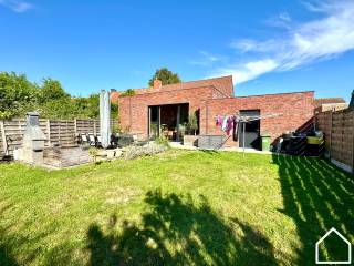 HALFOPEN WONING MET 2 SLPKS (3 MOGELIJK), GARAGE EN TUIN<br />Indeling: <br />Glv: inkomhall (3m²) - ruime living met open ingerichte keuken met kookeiland en vaatwas, inductie-kookplaat, frigo, aparte diepvries, oven en steamer, microgolf en spoelbak +1/2 (65m²) - berging (2,5m²) - wasruimte (4m²) -  gastentoilet - badkamer (6.5m²) met inloopdouche, wastafel en toilet + ruimte voor dressing (4m²) - zongerichte tuin (190m²) met terras die toegankelijk is via het schuifraam in de living - garage (3,6m op 5.55m) - oprit voor de garage (4.9m op 5.2m)<br />Verdiep: 2 slaapkamers (22m² - 13.5m²)<br />Bij het bouwen van de garage werd de fundering zwaar genoeg gemaakt om een derde slaapkamer in te richten op de garage.<br />Extra: overal hoogrendementsglas in aluminium - centrale ligging nabij basisschool, bakker, beenhouwer, Spar, ... - vlotte verbinding met de A19 - de woning is asbestveilig
