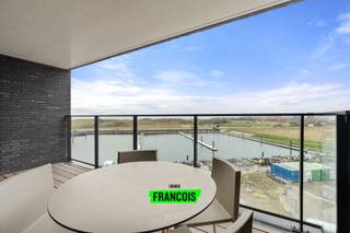 Dit ruime twee slaapkamerappartement bevindt zich op de Oosteroever te Oostende. U heeft hier tal van nieuwe handelaars, prachtig aangelegde wandelpaden en u bereikt in een handomdraai het centrum. Daarenboven heeft u hier steeds directe voeling met de zee.<br /><br />Het pand werd luxueus afgewerkt en geniet van prachtige verzichten. <br /><br />De lichtrijke leefruimte is voorzien van een karaktervolle uitstraling dankzij de raampartijen, openheid en parketvloeren. Vanuit de leefhoek is er een naadloze aansluiting met een eetplaats alsook open keuken. Deze keuken werd van al het nodige voorzien; gaande van moderne apparatuur tot kast-en werkruimte. Het grote kookeiland maakt de kookervaring compleet. <br /><br />Achterin het appartement zijn er twee ruime slaapkamers aanwezig. Deze zijn beiden voorzien van grote ingebouwde kasten. Er zijn daarenboven twee badkamers, elk voorzien van lavabo en grote inloopdouche. Vanop het overdekte terras geniet u steeds van prachtige zichten en kunt u volledig tot rust komen. <br /><br />De handige technische berging zorgt voor de nodige stockageruimte. <br /><br />Tot slot is er nog een mogelijkheid tot garagebox in het garagecomplex in de benedenverdieping van de residentie. <br /><br />Bent u op zoek naar een perfect afgewerkt appartement, op wandelafstand van de zee?<br /><br />Aarzel dan niet en neem contact op voor meer info of een afspraak. <br /><br />