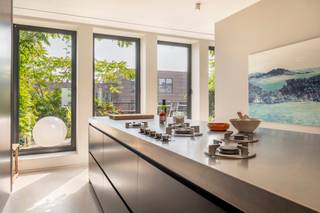 <p>OPEN HOUSE ZATERDAG 25/10 OM 11U.</p>
<p>SCHRIJF U IN <span>VIA DEZE KNOP</span> OF DOOR ONS TE CONTACTEREN OP 03/227 06 36 - WELCOME@DEMEESTER.EU<br /><br /></p>
<p>In het hart van Antwerpen, vlak bij het Centraal Station, winkelstraten, musea en luxeboetieks, ontdekt u dit unieke appartement.</p>
<p>De lift brengt u rechtstreeks naar de zesde verdieping, waar u binnenstapt in een lichtrijk appartement. De woning onderging in 2009 een grondige totaalrenovatie, uitgevoerd in een eigentijdse loftstijl met oog voor hoogwaardige afwerking.</p>
<p>De inkomhal met vestiaire en gastentoilet leidt u naar de open keuken, afgewerkt met marmer, inox en kwalitatieve toestellen van Miele. De aansluitende eetkamer met gashaard vormt een uitnodigende leefruimte waar koken en gastvrijheid centraal staan. Verder vindt u een aparte tv-kamer, die eveneens als tweede slaapkamer kan fungeren. Deze ruimte is uitgerust met schuifdeuren, een elektrisch uitschuifbaar bed en een aparte douchekamer.</p>
<p>Aan de andere zijde van de inkomhal bevindt zich de master suite met dressing en open badkamer in strak design, die naadloos doorloopt naar de keuken. Grote raampartijen en het terras creëren een harmonieus samenspel van licht en privacy. Alle ruimtes zijn bovendien afsluitbaar met schuifdeuren, waardoor u telkens een gevoel van rust en intimiteit behoudt. Over de volledige lengte van het appartement loopt een aangenaam terras van ca. 39 m², perfect voor een ochtendkoffie in de zon.</p>
<p>Een trap brengt u naar de zevende verdieping, waar zich momenteel een bureau, zomerkeuken en extra sanitair bevinden. Deze ruimte kan eenvoudig dienstdoen als derde slaapkamer. Absolute blikvanger is echter de uitzonderlijke daktuin van 172 m², uitgerust met een gasleiding voor barbecue, een automatisch sproeisysteem en een nieuw dak (2021). Hier geniet u zorgeloos van een oase van rust midden in de stad.</p>
<p>Extra comfort wordt geboden door Sonos-installatie, warmteluchtverwarming met koeling en bijkomende bergingen achter plafondhoge deuren.<br /><br />Bij dit appartement horen bovendien twee staanplaatsen die aangekocht kunnen worden aan 45.000;-EUR/ plaats en een ruime kelderberging.</p>