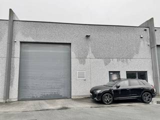 Op zoek naar een efficiënte en strategisch gelegen magazijnruimte, ideaal gesitueerd op een goed uitgerust industrieterrein? Dit degelijke gebouw biedt een uitstekende basis voor uw logistieke en bedrijfsbehoeften.

Locatie en Bereikbaarheid:
Gelegen op een dynamisch industrieterrein, geniet dit magazijn van een uitmuntende toegankelijkheid dankzij de nabijheid van belangrijke verkeersaders. Het terrein is voorzien van verlichting, groen en ruime parkeermogelijkheden, inclusief vier private parkeerplaatsen direct aan uw magazijn, wat een moeiteloze aan- en afvoer van goederen mogelijk maakt.

Kenmerken en Voorzieningen:
- Afmetingen: De magazijnruimte beslaat een oppervlakte van 321,6 vierkante meter, met een praktische breedte van 12 meter en een diepte van 26,8 meter.
- Toegang: Voorzien van een robuuste toegangspoort met een breedte van 4 meter en een hoogte van 4,5 meter, garandeert het gebouw een vlotte toegankelijkheid voor leveringen en transport.
- Interne Specificaties: Een vrije hoogte binnenin van 5,5 meter, samen met efficiënte TL-verlichtingsarmaturen, creëert een ruime en goed verlichte werkomgeving. De toevoeging van een tussenverdieping biedt extra stapelruimte, optimaal benut voor uw opslagbehoeften. Onder de stapelruimte bevindt zich een bureelruimte, badend in natuurlijk daglicht, perfect voor administratieve taken of klantenontvangst en een toilet.

Deze magazijnruimte is bijzonder geschikt voor een breed scala aan activiteiten, waaronder distributie, productie, opslag of als centrale hub voor e-commerce logistiek. Met de aangeboden faciliteiten en locatievoordeel biedt dit magazijn de ideale oplossing voor bedrijven die streven naar efficiëntie en groei.

Voor meer informatie of het plannen van een bezichtiging, nodigen we u graag uit contact op te nemen met Vastgoed Unicum op 09 336 16 15 of mail verhuur@vastgoedunicum.be. Ontdek hoe deze professionele magazijnruimte uw bedrijfsvoering kan ondersteunen en versterken.