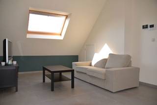 <p>Energiezuinig instapklaar dakappartement op de derde verdieping van een uitstekend onderhouden gebouw biedt een perfecte balans tussen comfort, energiezuinigheid en een centrale ligging. U bereikt de woning gedeeltelijk via de lift en komt binnen in een sfeervolle, open leefruimte. Dankzij de royale oppervlakte kan deze kamer naar eigen smaak worden onderverdeeld in een gezellige zithoek en een ruime eetkamer. Een praktische extra hier is de eerste, ruime berging die discreet in de woonruimte is geïntegreerd.</p>
<p>De leefruimte loopt naadloos over in de volledig ingerichte open keuken, uitgerust met kwaliteitsvolle toestellen. Direct tegenover de keuken bevindt zich de toegang tot het zonnige terras, ideaal om buiten te tafelen of te ontspannen.</p>
<p>Via een kleine nachthal bereikt u de overige ruimtes: namelijk een gastentoilet met handenwasser, een tweede, functionele berging met aansluitingen voor wasmachine en droogkast alsook de slaapkamer met directe toegang tot de aangrenzende badkamer, voorzien van een douche en wasmeubel.</p>
<p>Als grote troef beschikt het appartement over een private, overdekte staanplaats in de afgesloten ondergrondse parkeergarage. Hierdoor bent u altijd verzekerd van een veilige parkeerplek in het centrum. Met een uitstekende EPC-score en een lage maandelijkse vaste kost van slechts € 40,-, geniet u hier van zorgeloos wonen op wandelafstand van winkels, horeca en het openbaar vervoer.</p>