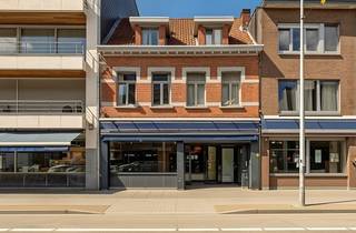 Op een uitstekende commerciële locatie nabij de markt van Brasschaat bevindt zich dit ruime en veelzijdige handelsgelijkvloers, geschikt voor diverse commerciële doeleinden zoals een winkel, kantoor, praktijkruimte of vrij beroep.<br /><br />Bij het betreden van het pand komen we in de ruime en lichtrijke commerciële winkelruimte, die voorheen ingericht was als chocolatier. De ruimte beschikt over een granieten toog en etalage, waardoor ze meteen een professionele en verzorgde uitstraling heeft en tal van mogelijkheden biedt voor een nieuwe handelszaak.<br />Aansluitend bevindt zich een ruim atelier, ideaal als werkruimte, extra commerciële oppervlakte of praktische bergruimte. Vanuit het atelier is er tevens toegang tot een kleine kelderruimte die dienst doet als technische lokaal.<br />Achteraan het pand vinden we een ruim magazijn, uitgerust met sanitaire voorzieningen. Een bijkomende troef is de achteringang via de Van Hemelrijcklei, die toegang geeft tot een ruime achtertuin. Deze praktische ontsluiting biedt mogelijkheden tot het creëren van een aangename buitenruimte of extra parking.<br /><br />Dankzij de strategische ligging aan de Bredabaan, vlakbij de markt van Brasschaat, geniet dit pand van een uitstekende zichtbaarheid en bereikbaarheid. <br /><br />Een uitstekende opportuniteit voor ondernemers, zelfstandigen of vrije beroepen die op zoek zijn naar een ruime commerciële locatie met een sterke ligging en een praktische indeling.<br /><br />De videotour, het grondplan en  het EPC kan u reeds bekijken via de Wellimmo-site ('documenten')<br /><br />📩 Meer info of een bezoek: info@wellimmo.net<br />📞 03/225 00 68 