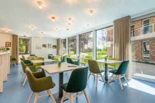 De assistentiewoning krijgt in Villa Moeie een geheel nieuwe dimensie. Grote glaspartijen vloeien moeiteloos over in een strak gebouw. Ruime, overdekte terrassen maken het mogelijk om optimaal van het buitenleven te genieten. Dit gevoel wordt versterkt door de gezamenlijke tuin, waar men onder het tuinpaviljoen kan samenkomen voor een drankje of een babbel. De groene vingers zijn in de nabijgelegen moestuin in hun sas. Sportievelingen vinden zeker hun gading aan de petanquebaan.
Dit nieuwbouwproject omvat 2 gebouwen, het villagebouw en het residentiegebouw. Beiden beschikken over een eigen technische ruimte en fietsenstalling. Hier kunnen ook scootmobiels gestald en opgeladen worden.
In het residentiegebouw op de hoek van de Moeie en de Tieltsesteenweg, worden 27 assistentiewoningen afgewisseld met gemeenschappelijke ruimtes. Hier is onder meer het bureau van de woonassistent gevestigd. Daarnaast is er ook een ontmoetingsruimte met bar en salon, bezoekerstoilet en afvalberging.
Het aparte villagebouw bestaat uit 8 assistentiewoningen, en evenveel private kelders.
De 34 parkeerplaatsen zijn als volgt verdeeld:
- 3 parkeerplaatsen voor zorgverstrekkers en woonassistenten
- 2 (minder)valide bezoekersparkeerplaatsen
- 29 privatieve parkeerplaatsen met gepersonaliseerde beveiligde toegang.
Elke flat heeft een eigen water- en elektriciteitsteller, inbraakwerende voordeur en warmtepomp. Een afzonderlijke inkomhal zorgt voor privacy, de open keuken in de lichtrijke leefruimte maakt het aangenaam om familie en vrienden te ontvangen. De slaapkamers zijn royaal van grootte, zodat een dubbel bed én een kast er makkelijk passen. In de badkamer zijn discreet hulpmiddelen aangebracht, zoals een zitje in de douche en een handgreep naast het toilet.
Het gehele park is rolstoeltoegankelijk. Doorheen het appartement kan de bewoner een alarm activeren, of de zorgassistent bereiken voor meer hulp. Kortom, sfeer, comfort en hulp waren nog nooit zo toegankelijk!
Wenst u meer info over dit unieke project?
Bel dan Nic van Unicum voor een verhelderend gesprek op 09 336 16 15.