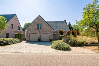 IN OPTIE!! Sommige woningen overtuigen door de manier waarop alles samen klopt. Deze ruime villa in een doodlopende, kindvriendelijke straat combineert een bijzonder doordachte indeling met veel licht, groen en een uitstekende zuidwestelijke oriëntatie. Grote raampartijen brengen de tuin tot diep in de woning en zorgen voor een aangenaam gevoel van ruimte en rust.<br /><br /><strong>Ligging</strong><br />De Steenboklaan geniet van een uitzonderlijk rustige, residentiële ligging in Sint-Job-in-'t-Goor, met weinig tot geen verkeer en veel groen in de omgeving. Winkels, scholen en dagelijkse voorzieningen bevinden zich vlot binnen bereik, net als de E19 richting Antwerpen en Breda. Ook voor wandelaars en fietsers bieden de nabijgelegen bossen, de vaart en de Antitankgracht een prachtige omgeving.<br /><br /><strong>Indeling</strong><br />Via de brede oprit met ruime parkeergelegenheid en dubbele inpandige garage bereikt u de centrale inkomhal met vestiaire en gastentoilet.<br /><br />Aan de ene zijde bevindt zich het leefgedeelte, waar woonkamer, lees- en zithoek, eetruimte en keuken op een natuurlijke manier in elkaar overvloeien. De vele raampartijen zorgen hier voor een overvloed aan daglicht en een mooi zicht op de rijk beplante tuin. De keuken werd afgewerkt met natuursteen en sluit aan op de veranda, een heerlijke plek om doorheen het jaar te genieten.<br /><br />Aan de andere zijde geeft een praktische hal toegang tot de garage, een slaapkamer, complete badkamer en ruime was- en berging met ingemaakte kasten. Hierdoor is ook gelijkvloers wonen perfect mogelijk.<br /><br />De doordachte indeling zorgt voor een natuurlijke verbinding tussen de verschillende ruimtes. De karaktervolle travertinvloer loopt door over verschillende ruimtes en de trap, wat voor visuele rust en een mooi gevoel van samenhang zorgt.<br /><br /><strong>Op de eerste verdieping</strong> bevinden zich vijf slaapkamers, waarvan één is ingericht als bureau en een andere als dressing, en een ruime tweede badkamer met douche, toilet en plaats voor een ligbad of sauna.<br /><br /><strong>De tweede verdieping</strong> biedt nog een ruime opbergzolder.<br />Verder beschikt de woning over een wijnkelder en een kruipruimte onder de gehele woning.<br /><br /><strong>Tuin</strong><br />De groene, volwassen tuin geniet van een uitstekende zuidwestelijke oriëntatie en veel privacy. Aan de woning bevindt zich een ruim terras met zonneluifel, terwijl achteraan nog een tweede terras werd aangelegd.<br /><br /><strong>Bijzonderheden</strong><br />Uitstekende ligging, 6 slaapkamers, 2 badkamer, Zuidwest tuin, EPC: B, 20 zonnepanelen, twee airco-units, kwalitatieve ingemaakte kasten en duurzame materialen.