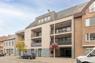 <p>In een verzorgd gebouw van 2018 vind je dit modern en energiezuinig appartement op de tweede verdieping, vlot bereikbaar met lift en trap. De leefruimte is ruim en lichtrijk dankzij de grote raampartijen en geeft rechtstreeks toegang tot het overdekte terras – een aangename plek om in alle rust van de buitenlucht te genieten.</p>
<p>De open keuken sluit mooi aan op de leefruimte en is volledig uitgerust met hedendaagse toestellen. Aansluitend bevindt zich een praktische berging met aansluiting voor wasmachine en droogkast. Aan de achterzijde van het appartement zijn er twee volwaardige slaapkamers en een stijlvolle badkamer met dubbele lavabo en inloopdouche.</p>
<p>Het appartement is volledig instapklaar en voorzien van airconditioning, een conforme elektrische keuring en een uitstekende energieprestatie (EPC A).</p>
<p>Ondergronds zijn er twee autostaanplaatsen beschikbaar, aan te kopen mits een meerprijs van € 25.000 per staanplaats.</p>
<p>De ligging is bijzonder aangenaam: op wandelafstand van winkels, scholen en openbaar vervoer. Dankzij de nabijgelegen invalswegen bereik je vlot Mechelen, de E19 en de omliggende gemeenten.</p>
<p>Een comfortabel, recent en energiezuinig appartement voor wie zorgeloos wil wonen op een centrale en goed bereikbare locatie.</p>
<p> </p>