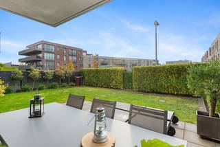 Het appartement is centraal gelegen in Schoten, nabij openbaar vervoer, winkels, scholen, parken en belangrijke invalswegen. Tevens bereikt u op slechts 15 minuten fietsen het Eilandje (Antwerpen).<br />Deze moderne, recente residentie werd gebouwd in 2015 en voldoet aan alle huidige normen. <br /><br />We betreden dit mooi appartement via de inkomhal dewelke ons toegang geeft tot de ruime, lichtrijke leefruimte met open keuken. De volledig geïnstalleerde keuken is voorzien van een vaatwasser, een koelkast, een diepvriezer en een inductie kookplaat. Deze open ruimte geniet van ingebouwde spots. <br />Via het schuifraam in de leefruimte bereiken we de grote, zonnige ZW-tuin met terras waar u gezellig buiten kan vertoeven tijdens mooi weer. <br /><br />Verder bestaat het appartement uit twee ruime slaapkamers (12m² / 10m²) waarvan de grootste is voorzien van airco en een aansluiting voor televisie. <br />De badkamer is uitgerust met een enkele lavabo, een toilet, een douche, een ligbad en tevens ingebouwde spots. Vervolgens is er een praktische bergruimte aanwezig met aansluitingen voor een wasmachine en een droogkast. <br /><br />Tot slot beschikt dit appartement over een ondergrondse autostaanplaats met kelderberging dewelke verplicht bij aan te kopen zijn aan € 25.000.<br /><br /><strong>Troeven</strong>:<br />+ Gelijkvloers appartement<br />+ Grote ZW-tuin met terras<br />+ 2 ruime slaapkamers<br />+ Recent gebouw (2015)<br />+ Elektriciteit conform<br />+ Gunstige EPC-score<br />+ Ondergrondse autostaanplaats met berging (€ 25.000)<br />+ Centrale locatie in Schoten<br /><br />Heeft u interesse en wenst u een bezoek ter plaatse? Aarzel niet ons te contacteren op het nummer <strong>03 337 50 70</strong> of via<strong> info@vbvastgoed.be</strong>.