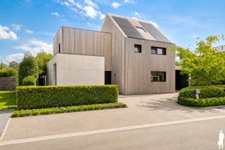 <strong>Unieke, af te werken architectenwoning gelegen in rustige, groen-agrarische omgeving in één van de mooiste wijken te Balen (Olmen), nabij Beverlo, Meerhout en Leopoldsburg. De villa biedt o.a. 4 à 6 ruime slaapkamers, 2 badkamers (waarvan één af te werken is), een uiterst lichtrijke, open leefruimte en een diepe, organisch ingerichte natuurtuin (met verschillende terrassen en verwarmd infinity-zwembad). Het geheel ligt op een perceel van ca. 2.001 m², uitzonderlijk gelegen nabij natuur (wandel- en fietsroutes) en achtergelegen agrarisch gebied. De abstracte woning ademt klasse, karakter, visie en rust. De woning met tuin is opgebouwd op verschillende niveaus, wat zorgt voor een speelse, open dynamiek. Pure materialen zoals zichtbeton, (padouk) hardhout, glas en aluminium staan centraal. De grote raampartijen halen de natuurlijke omgeving naar binnen en zorgen voor een fascinerende beleving van licht en ruimte. De villa is bovendien uiterst energiezuinig (zonnepanelen, CV-ketel WOLF (2021), warmtepomp, hoogrendementsbeglazing, etc.). Bepaalde ruimten dienen nog te worden geschilderd. Nabij scholen, openbaar vervoer en natuurreservaten (Keiheuvel & Nationaal Park Bosland). <br /><br /></strong><em>Gelijkvloers - eerste niveau</em><br /><br />Via de inkomhal met vestiairegedeelte en gastentoilet heeft u toegang tot de afzonderlijke praktijkruimte, de technische ruimte en waskamer. Het praktijkgedeelte is voorzien van wachtruimte. De hal leidt verder tot het privé-gedeelte (woonkamer, keuken, etc.). De leefruimte is verdeeld in een zitgedeelte (linkerzijde) met zwevende houtkachel, het eetgedeelte met achterliggende bureauruimte (centraal) en de open leefkeuken (rechterzijde). Deze leefruimte geniet van veel natuurlijk daglicht door de riante raampartijen die uitgeven op de diepe natuurtuin met verhoogd infinity-zwembad en vijverpartij. De keuken - met aansluitend ontbijtgedeelte - op hoogte is uitgerust met alle nodige kwaliteitstoestellen: inductievuur, heteluchtoven, Quooker, vaatwas, etc. (AEG, Faber, e.a.). Deze ruimte is evenwel verder af te werken.<br /><br />Via deze leefkeuken heeft u toegang tot de bijkeuken met extra gootsteen en inbouwkastruimte, alsook tot de zij-ingang (carport).<br /><br /><em>Bovenverdiep - tweede en derde niveau</em><br /><br />Op de bovenverdieping zijn er 3 ruime slaapkamers en een badkamer. De hoofdslaapkamer is voorzien van een eigen ensuite-badkamer (nog onafgewerkt) en een inloopdressing. Deze slaapkamer biedt een prachtig uitzicht op de tuin. De badkamer is voorzien van inloopdouche en toilet. De ingerichte zolderverdieping doet thans dienst als 4e slaapkamer maar kan perfect worden opgedeeld of worden gebruikt als multifunctionele ruimte (bv. hobbykamer).<br /><br /><em>Buiten- en tuingebeuren</em><br /><br />De woning biedt vooraan buitenparking op lavasteenkorrel. Parkeren kan zowel voor de woning als onder de carport in zichtbeton (met berging). Zowel in de voor- als achtertuin bevinden zich groenstructuren (hoge hagen, heesters en diverse typen grassen). De achtertuin is volledig aangelegd en ideeal georiënteerd op het oosten. De uitgestrektheid van deze tuin en de verschillende private terrassen zorgen ervoor dat u in verschillende tuindelen in alle sereniteit van zon of schaduw kan genieten. De natuurtuin is verder volledig omheind en organisch aangelegd. U vindt er naast verschillende heggen, bomen, heester en een aantal fruit- en notenbomen ook een infinity-zwembad (verwarmd én jetstream / tegenstroomsysteem). <br /><br /><span>Bijzonderheden</span>:<br /><span>- EPC van 93kWh/m²/jaar: energielabel A<br /></span>- Conforme elektrische keuring én asbestveilig<br />- Bew. opp. van maar liefst 347<span>m² (excl. kelder)</span><span><br /></span>- CV op aardgas en vloerverwarming<br />- Zonnepanelen en batterijklaar<br />- Riant perceel op oosten: 2.001<span>m²</span><br />- Renovatiejaar 2020-2024 - totaalrenovatie