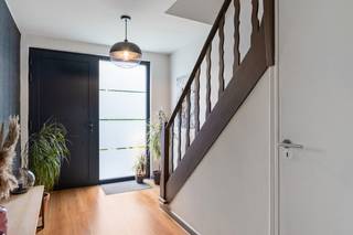 Deze instapklare bel-etagewoning met ruime oprit is ideaal gelegen op wandelafstand van het centrum van Kapellen, in de nabijheid van winkels, scholen en openbaar vervoer. De woning biedt een mooie combinatie van comfort, ruimte en een gunstige ligging. Bij het betreden van de woning komt u binnen in een ruime inkomhal met handige bergruimte onder de trap. Deze hal geeft toegang tot de erg ruime inpandige garage en een praktische berging met apart gastentoilet. Op de eerste verdieping bevindt zich een knap gerenoveerde, lichtrijke leefruimte met open keuken. De keuken is volledig uitgerust met alle nodige toestellen en beschikt over veel kastruimte. Verder vindt u op deze verdieping een apart gastentoilet. Op de tweede verdieping bevinden zich twee ruime slaapkamers en een nette badkamer met douche-in-bad, dubbele wastafel en handdoekradiator. Daarnaast is er op deze verdieping nog een extra berging, die u volledig naar eigen wens kan invullen, alsook nog een apart toilet. De woning is gelegen op een perceel van 230 m² en beschikt over een gezellige, groene tuin met aangelegd terras. Een heerlijke plek om even tot rust te komen, van het buitenleven te genieten of gezellig samen te tafelen.