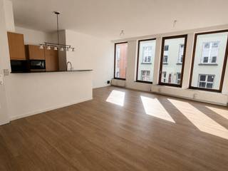 In de bekende Hoogstraat, in het hart van Antwerpen, bevindt zich dit uitstekend gelegen appartement. De vele restaurants, cafés en winkels maken van deze bruisende buurt een top locatie.<br /><br />Het appartement van ca. 89 m² is gelegen op de tweede verdieping. Dankzij de kamerhoge raampartijen geniet de woonruimte van een aangename lichtinval. De hoogwaardige, onderhoudsvriendelijke PVC-parketvloer zorgt voor een warme en ruimtelijke uitstraling.<br /><br />De open keuken is recent uitgerust met splinternieuwe toestellen: een kookplaat, heteluchtoven, vaatwasser, koelkast met ruim vriesvak en een microgolfoven. De hoge toog vormt een subtiele scheiding tussen de keuken en de leefruimte en creëert zo een ideale balans tussen openheid en functionaliteit.<br /><br />De masterbedroom bevindt zich aan de rustige achterzijde. Ook de tweede slaapkamer is ruim en leent zich perfect als logeerkamer, kinderkamer of bureau. Beide kamers maken gebruik van de badkamer, uitgerust met een ligbad met douche en een dubbele lavabo. Hier is tevens een aansluiting voorzien voor een wasmachine en droogkast.<br /><br />De gemeenschappelijke binnentuin biedt een oase van rust, waardoor u even vergeet dat u zich in het centrum van Antwerpen bevindt.<br /><br />Een ondergrondse autostaanplaats kan worden bijgehuurd voor € 130 per maand.<br /><br />Gemeenschappelijke kosten: 130 Euro per maand.<br />Provisie op verbruik van water: 35 Euro per maand.<br />Nutsvoorzieningen gas en elektriciteit zijn privé op te nemen door de huurder.<br /><br />Onmidellijk beschikbaar.
