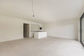 Dit recent opgeleverde appartement heeft een praktische indeling. Via de ruime inkomhal met gastentoilet kom je terecht in de lichte en riante leefruimte met open keuken. De moderne keuken is afgewerkt met een natuurstenen werkblad en volledig uitgerust met kwalitatieve toestellen, waaronder een inductiekookplaat, dampkap, oven, vaatwasmachine en ingebouwde koelkast. Vanuit de woonkamer heb je directe toegang tot de zonnige, mooi aangelegde tuin met terras. Achteraan de tuin bevindt zich een ruime garage van maar liefst 35m², afzonderlijk aan te kopen voor 35.000 euro (excl. kosten), alle voorzieningen voor een laadpaal zijn reeds voorzien. Het appartement beschikt verder over twee ruime slaapkamers, een extra dressing en een stijlvolle badkamer met dubbele lavabo en inloopdouche. Daarnaast is er een handige berging met aansluiting voor een wasmachine. Bovendien voldoet het appartement aan alle hedendaagse energienormen en is het voorzien van vloerverwarming, een warmtepomp, zonnepanelen, ventilatiesysteem C en regenwaterrecuperatie voor de toiletten en mogelijk ook de wasmachine. Zo geniet u van een energiezuinig en comfortabel woonklimaat. Extra troef: het verwachte E-peil bedraagt minder dan E20, wat recht geeft op een korting van 50% op de onroerende voorheffing gedurende 5 jaar. AANKOOP MOGELIJK AAN 6% BTW! Contacteer ons voor meer info op 03 568 03 03 of lauren@vastgoed03.be 