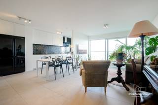 U kan zich inschrijven voor de bezoekmomenten via de website.<br /><br />Dit stijlvol, modern afgewerkt en instapklaar appartement van 99m2, baadt dankzij de dubbele oriëntatie de hele dag in het licht. U geniet aan beide zijden van een eigen terras met vergezicht. Een doordachte indeling scheidt de leefruimte, via een ruime doorloop, van de slaapkamer. <br /><br />De living met eethoek vormt het hart van de woning. Via brede schuiframen stapt u het terras op, waar de glazen balustrade het zicht vrijhoudt: dé plek voor een zondagsontbijt of een aperitief terwijl de stad onder u oplicht. De open keuken met inbouwoven, kookplaat en een kamerhoge kastwand met nis voor een Amerikaanse koelkast biedt bergruimte in overvloed, in combinatie met een prachtig uitzicht. <br /><br />Aan de andere zijde ligt een royale, lichtrijke slaapkamer met o.a. ingemaakte kasten, plaats voor een bureau- of leeshoek en rechtstreekse toegang tot het tweede terras. Hier wordt u wakker met een zicht op de andere kant van Gent. De ruim opgevatte badkamer beschikt over een inloopdouche, een lavabo en een zwevend toilet. Bovendien is het appartement volledig rolstoeltoegankelijk, wat comfortabel wonen garandeert voor vandaag én later.<br /><br />Ten slotte biedt een afgesloten garagebox plaats aan uw wagen, fietsen of extra spullen en maakt het plaatje compleet.<br /><br />Licht, ruimte, privacy en een uitzicht dat nooit verveelt, met het bruisende stadsleven binnen handbereik.