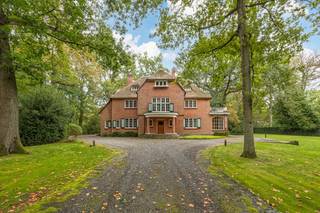 Bekijk alvast de videotour, het EPC, EK, grond en omgevingsplannen, asbestinventaris,..... via de Wellimmo-site ('documenten').<br /><br />Verscholen in het groen van het gegeerde Vriesdonk bevindt zich deze statige rietgedekte villa uit 1924. Het eigendom combineert een indrukwekkende woonoppervlakte van circa 518 m² met een uitzonderlijk perceel van ruim 9.127 m². De lange, verlichte oprijlaan, de diepe omheinde parktuin en de authentieke architectuur zorgen voor bijzonder veel uitstraling en privacy.<br /><br />De woning is vandaag aan een grondige renovatie toe, maar biedt dankzij haar royale volumes, hoge plafonds en karaktervolle elementen een unieke basis voor de realisatie van een exclusieve familievilla. Volgens het EPC kan de woning bovendien worden gerenoveerd tot energielabel A.<br /><br />Op het gelijkvloers leidt de inkomhal met vestiaire en gastentoilet naar een indrukwekkende centrale ontvangsthal van circa 22 m². Aansluitend bevinden zich een ruime woonkamer van circa 37 m² en een eetkamer van circa 28 m², beide met houten vloer, open haard en rechtstreekse toegang tot het overdekt terras en de tuin. Verder zijn er een afzonderlijke bijkeuken, bar, een royale keuken van circa 30 m², een wasplaats, berging, toilet, toegang tot de kelder van 170 m² en een inpandige garage. De bestaande indeling biedt mooie mogelijkheden om een open leefkeuken te creëren en de leefruimtes eigentijds met elkaar te verbinden.<br /><br />De tussenverdieping omvat een toilet en bergruimte. Op de eerste verdieping liggen vier volwaardige slaapkamers, waaronder een hoofdslaapkamer van circa 28 m² met uitzicht op het park en een ensuite badkamer. Vanuit één van de slaapkamers is een bijkomende kamer van circa 23,5 m² bereikbaar, ingericht als slaapruimte met aparte bureelhoek. Ook het realiseren van een tweede badkamer behoort hier tot de mogelijkheden.<br />De tweede verdieping omvat nog drie slaapkamers en twee aansluitende zolderkamers. Daarmee beschikt de villa in totaal over acht slaapkamers en bijzonder veel flexibiliteit voor een groot gezin, een thuispraktijk, kantoorruimte of logeerverblijven.<br /><br />Daarnaast is er een ruime kelderverdieping met meerdere bergingen en een wijnkelder. Achteraan op het domein bevindt zich een vrijstaande dubbele garage met zolderberging. Samen met de inpandige garage en de ruime parkeermogelijkheden op het terrein biedt dit plaats aan meerdere wagens.<br /><br />De sfeervolle, oost-west gerichte parktuin strekt zich uit over een diepte van circa 163 tot 167 meter en beschikt aansluitend aan de villa over een overdekt terras. De volgroeide begroeiing en lange oprijlaan creëren een zeldzaam gevoel van rust en afzondering, terwijl scholen, winkels en belangrijke verbindingswegen vlot bereikbaar blijven.<br />Een uitzonderlijk totaal renovatieproject voor wie op zoek is naar ruimte, karakter en privacy op een van de meest begeerde residentiële locaties van Brasschaat.<br /><br /><strong>Bijzonderheden</strong>
<ul>
<li><span>Perceeloppervlakte: circa 9.128 m²</span></li>
<li><span>Woonoppervlakte: circa 518 m²</span></li>
<li><span>Gevelbreedte: circa 21 meter</span></li>
<li><span>Acht slaapkamers</span></li>
<li><span>Drie garages en ruime parkeermogelijkheden</span></li>
<li><span>Diepe, volledig omheinde en oostgerichte parktuin</span></li>
<li><span>Authentieke elementen, hoge plafonds en meerdere open haarden</span></li>
<li><span>Verwarming op stookolie via radiatoren</span></li>
<li><span>Rieten dak circa vijf jaar geleden onderhouden</span></li>
</ul>
Tevens mogelijkheid tot aankoop van de naastliggende van ca. 4.543m² met een frontbreedte van 34,8m met achterliggend tennisveld (prijs op aanvraag).<br /><br />Voor meer info en uw bezoek bel 03.225.00.68 of info@wellimmo.net<br />
