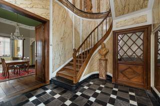 <h3>UNIEK HISTORISCH HERENHUIS MET HANDELSRUIMTE, 6 SLAAPKAMERS, TUIN EN GARAGEBOUW IN HARTJE BORGLOON.</h3>
<p><br />Droomt u ervan eigenaar te worden van een uitzonderlijk stukje erfgoed? Aan de Markt 1 in Borgloon bieden wij u een zeldzame opportuniteit: een karaktervol kanunnikenhuis met handelsruimte, zes slaapkamers, een prachtige stadstuin en een afzonderlijk garagegebouw. Dit monumentale pand bevindt zich op een toplocatie in het bruisende stadscentrum van Borgloon, op wandelafstand van winkels, horeca, scholen en andere voorzieningen. Bovendien geniet u van een uitstekende verbinding naar Wellen, Tongeren, Kortessem en Hasselt.</p>
<p><br />Dit indrukwekkende pand, gekenmerkt door zijn neoclassicistische architectuur en verfijnde Lodewijk XVI-elementen, combineert historische grandeur met een waaier aan gebruiksmogelijkheden. Dankzij de combinatie van wonen en ondernemen is dit eigendom ideaal voor wie op zoek is naar een karaktervolle gezinswoning met commerciële mogelijkheden, een praktijkruimte, kantoor of een investering met toekomstpotentieel.</p>
<p><br />Bij het betreden van het pand komt u eerst in een ruime polyvalente handelsruimte die nog volledig naar eigen smaak kan worden ingericht. Vanuit deze ruimte heeft u directe toegang tot het achterliggende terras en de charmante tuin, die tevens uitkomt op de straat Nieuwland. Achteraan bevindt zich bovendien een afzonderlijk gebouw dat momenteel dienstdoet als garage en parkeergelegenheid.</p>
<p><br />Vanuit de handelsruimte bereikt u de woongedeeltes van deze statige burgerwoning. Meteen vallen de indrukwekkende plafondhoogtes, authentieke afwerkingen en karaktervolle details op. Op het gelijkvloers bevinden zich een ruime leef- en eetkamer, een gemoderniseerde keuken, een ingerichte badkamer en een imposante trappenhal. Het prachtig uitgewerkte faux-marble in deze hal vormt zonder twijfel één van de blikvangers van het pand.</p>
<p><br />Op de eerste verdieping bevinden zich maar liefst zes slaapkamers van verschillende afmetingen. Elke ruimte ademt authenticiteit en biedt tal van mogelijkheden voor gezinsbewoning, gastenverblijven, bureauruimtes of andere invullingen. Via een discreet weggewerkte diensttrap, die doorloopt tot in de kelder, bereikt u de ruime zolderverdieping. De zichtbare houten dakconstructie verleent deze ruimte extra charme en potentieel voor verdere inrichting.</p>
<p><br />Ook buiten wordt de historische uitstraling van het eigendom verdergezet. Het terras en de sfeervolle stadstuin vormen een oase van rust in het centrum van de stad. De authentieke scheidingsmuur met het naastgelegen pand benadrukt bovendien het historische karakter van deze unieke locatie. <br /><br /><br />Dit kanunnikenhuis is erkend als beschermd monument en maakt deel uit van een beschermd stadsgezicht. Dankzij een grondige restauratiefase tussen 2009 en 2013 beschikt de toekomstige eigenaar reeds over een sterke basis voor verdere renovatie of herbestemming. Daarnaast geldt er geen renovatieverplichting, en kunnen eigenaars in aanmerking komen voor diverse erfgoedsubsidies en financiële ondersteuningsmaatregelen om het pand verder te moderniseren met respect voor zijn historische waarde.</p>
<p><br />Dit unieke eigendom wacht op een nieuwe eigenaar die zijn rijke geschiedenis verder wil schrijven. Contacteer ons vandaag nog voor meer informatie of een bezichtiging via <strong>info@momentumvastgoed.be</strong> of telefonisch op <strong>011 96 51 76</strong>.</p>