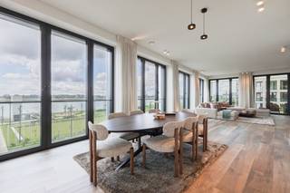 <p>Welkom in dit stijlvolle en lichtrijke appartement op de tweede verdieping, waar luxe, comfort en een uitzonderlijke ligging samenkomen. Dankzij de grote raampartijen geniet u de hele dag van een overvloed aan natuurlijk licht en een prachtig, onbelemmerd uitzicht over de Schelde.<span></span></p>
<p>De royale leefruimte vormt het hart van de woning en sluit naadloos aan op de volledig uitgeruste designkeuken, voorzien van hoogwaardige <strong>Miele-toestellen</strong>. De kwalitatieve afwerking en het tijdloze interieur creëren een elegante en warme woonbeleving.</p>
<p>Het appartement beschikt over <strong>drie ruime slaapkamers</strong> en <strong>twee stijlvolle badkamers</strong>, waarvan één is uitgerust met een comfortabel ligbad. Ideaal voor wie op zoek is naar ruimte en privacy.</p>
<p>Buitenleven staat hier centraal met <strong>twee terrassen</strong>: een gezellig <strong>binnenterras</strong> en een ruim <strong>buitenterras</strong>, waar u op elk moment van de dag kunt genieten van de rust en het indrukwekkende uitzicht op de Schelde.<br /><br />Extra troeven zijn de <strong>twee private autostaanplaatsen</strong> en maar liefst <strong>drie praktische bergingen</strong>, die zorgen voor extra comfort en voldoende opbergruimte.</p>
<p>Een exclusief appartement dat uitblinkt in ruimte, licht en een unieke ligging aan het water. De perfecte keuze voor wie op zoek is naar comfortabel wonen met een uitzonderlijk uitzicht.</p>