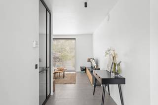 <p>Bent u op zoek naar de perfecte balans tussen een centrale ligging, modern comfort en een sfeervolle, smaakvolle inrichting? Deze recente en trendy 3-gevelwoning uit <strong>2024</strong> biedt het allemaal. Gelegen in de directe nabijheid van scholen en het bruisende centrum, en met een uitstekende verbinding naar de <strong>A12</strong>, geniet u hier van een toplocatie waar mobiliteit en rust hand in hand gaan.</p><p>Dankzij de high-end afwerking, een doordachte indeling en de integratie van een modern <strong>domoticasysteem</strong> is deze woning volledig klaar voor de toekomst.</p><h3>Een sfeervol en warm welkom</h3><p>Bij het betreden van de woning wordt u meteen verwelkomd in de stijlvolle inkomhal met gastentoilet. Doorlopend bereikt u de <em>cozy</em> leefruimte, die warmte en rust uitstraalt—de ideale plek voor een gezellig avondje voor de buis.</p><p>Aansluitend bevindt zich de absolute eyecatcher van het huis: de royale <strong>leefkeuken</strong>. Dit is een ware droom voor elke kookliefhebber. Uitgerust met hoogwaardige toestellen, een ingebouwde <strong>wijnkoeler</strong> en een riant kookeiland, leent deze ruimte zich perfect voor uitgebreid tafelen met vrienden en familie. Wat deze keuken écht uniek maakt, is het panoramische uitzicht op de tuin; een levend schilderij dat in elk seizoen een nieuwe belevenis biedt.</p><p>Praktisch comfort is er ook: de inpandige garage biedt niet alleen plaats voor de wagen, maar fungeert tevens als handige wasplaats en extra berging.</p><h3>Ruimte, comfort en flexibiliteit op de verdiepingen</h3><p>Op de eerste verdieping leidt de nachthal met apart toilet naar drie volwaardige slaapkamers. De <strong>master bedroom</strong> is een luxe suite op zich, compleet met een eigen, op maat gemaakte <strong>dressingkamer</strong>. De badkamer trekt de lijn van hoogwaardige afwerking feilloos door en is voorzien van alle comfort, waaronder een royale <strong>XL-douche</strong>.</p><p>Via een vaste trap bereikt u de reeds geïsoleerde en volledig afgewerkte <strong>zolderverdieping</strong>. Deze doet momenteel dienst als polyvalente ruimte, maar biedt de flexibiliteit om heel eenvoudig omgevormd te worden tot <strong>2 extra slaapkamers</strong> of een riant thuiskantoor.</p><h3>Strakke buitenomgeving</h3><p>Buiten is het genieten in de prachtig aangelegde tuin. De combinatie van de zorgvuldig gekozen beplanting en het strakke terras in <strong>gepolierde beton</strong> geeft het geheel een moderne, architecturale uitstraling en vraagt bovendien weinig onderhoud.</p><h3>De troeven in een oogopslag:</h3><ul><li><p><strong>Bouwjaar 2024:</strong> Volledig up-to-date, energiezuinig en instapklaar.</p></li><li><p><strong>High-end technieken:</strong> Uitgerust met domotica en een slimme, doordachte indeling.</p></li><li><p><strong>Droomkeuken:</strong> Voorzien van luxe-toestellen, wijnkoeler en een groot eiland.</p></li><li><p><strong>Ruimte & Potentieel:</strong> 3 slaapkamers (inclusief dressing) met de mogelijkheid tot 5 kamers dankzij de ingerichte zolder.</p></li><li><p><strong>Toplocatie:</strong> Nabij scholen, centrum en een vlotte verbinding met de A12.</p></li></ul><blockquote><p><strong>Bent u net zo enthousiast als ik?</strong> Laat deze unieke kans niet aan u voorbijgaan en plan vandaag nog uw bezoek.</p></blockquote><p></p>
